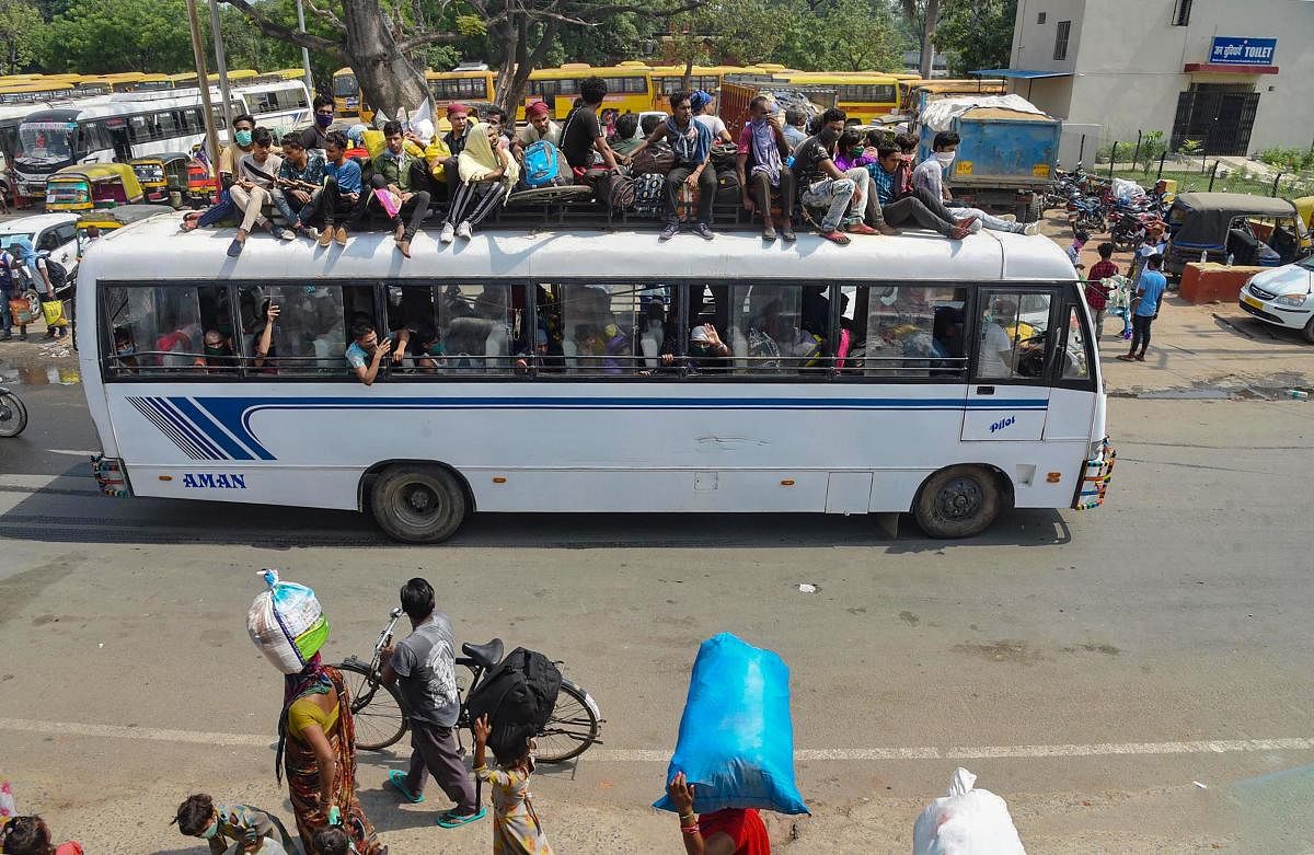  Migrants, not adhering to social distancing norms, leave in an overloaded bus to Danapur railway station. PTI