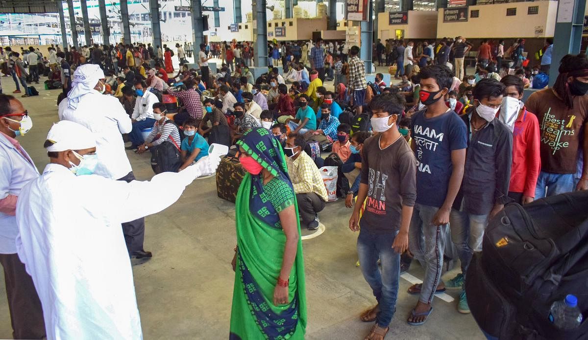 Migrants who have arrived from Ahmedabad in Gujarat undergo thermal screening after arriving by a special train at Prayagraj railway station, during the ongoing COVID-19 lockdown, in Prayagraj, Wednesday, May 13, 2020. (PTI Photo)