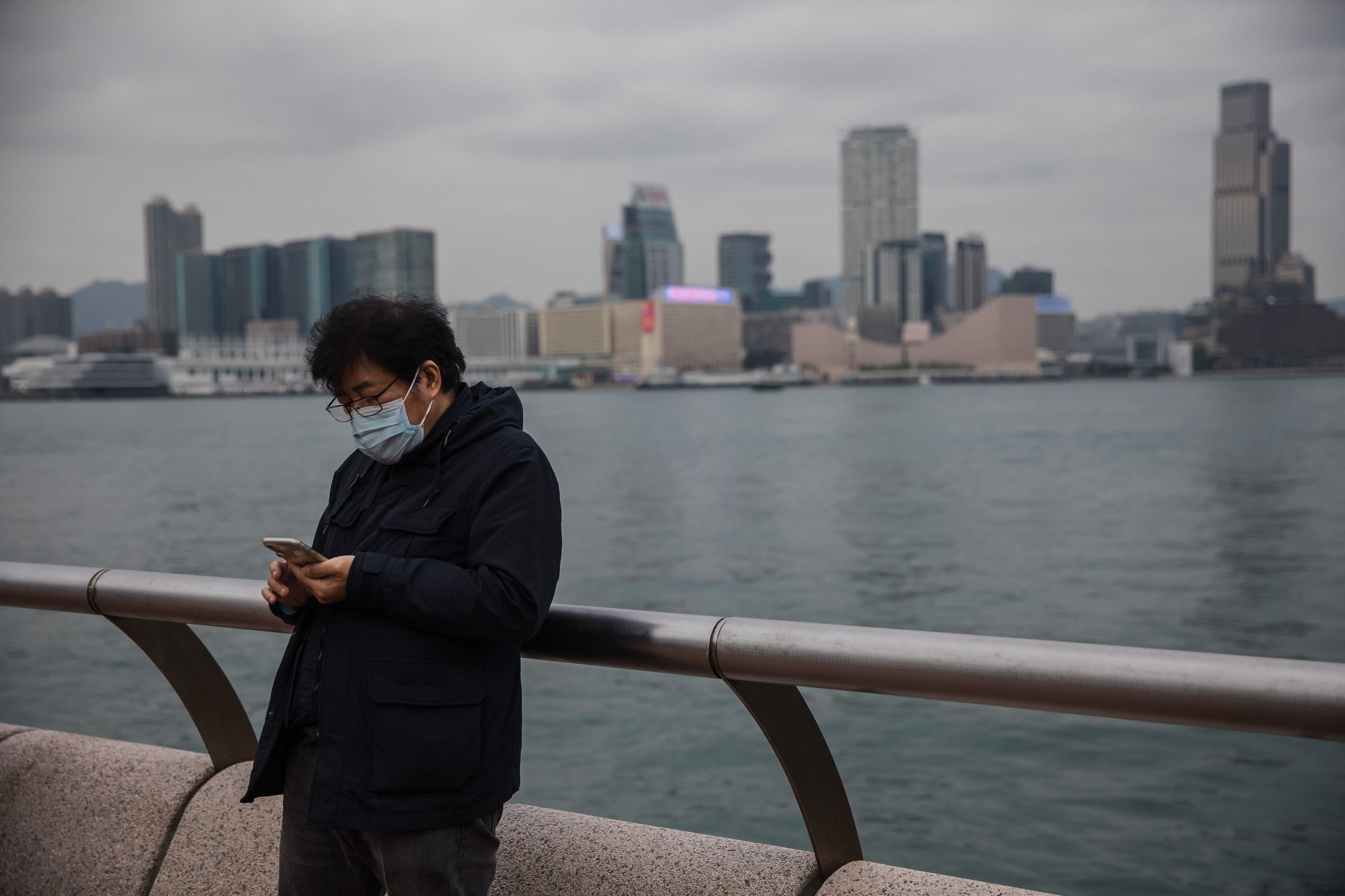 A man wearing a protective face mask uses his phone in Hong Kong on February 9, 2020, as a preventative measure after a coronavirus outbreak which began in the Chinese city of Wuhan. (AFP Photo)
