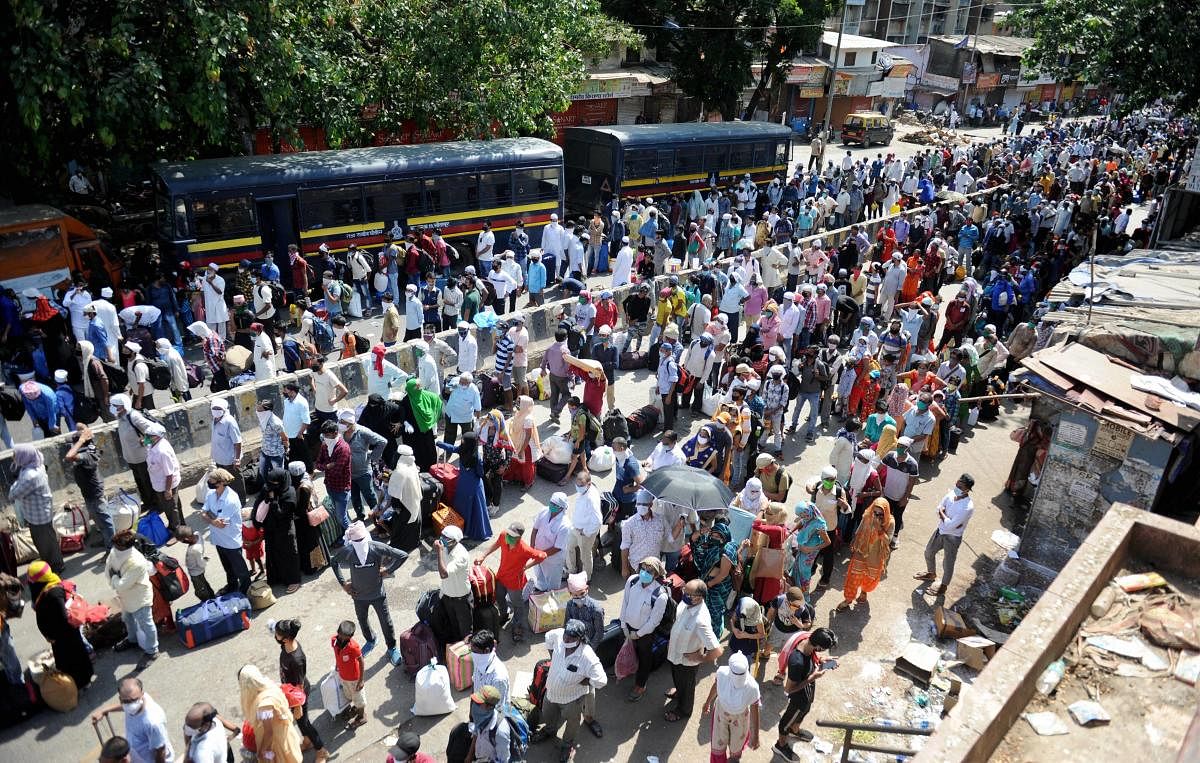 Migrants gather outside Dharavi slum to board buses for a railway station (PTI Photo)