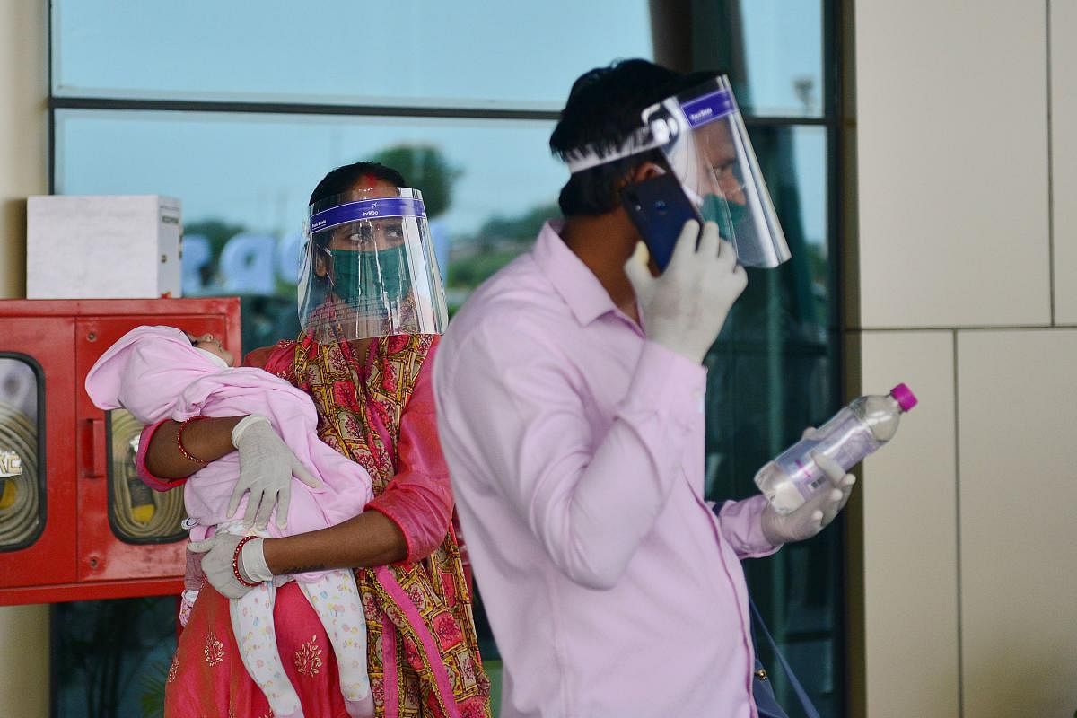 Passengers wearing protective face shields arrive at the Prayagraj domestic airport (AFP Photo)