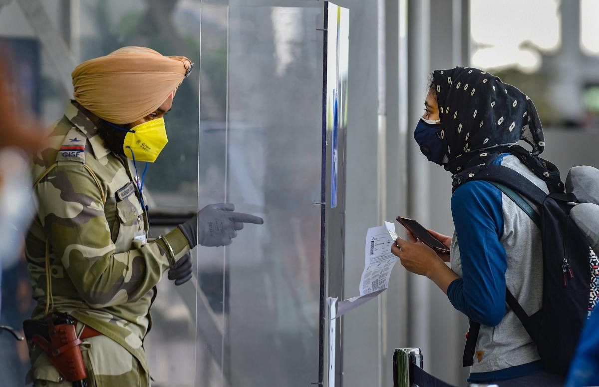 A security personnel checks a passenger's identity card as she arrives at Chennai airport for domestic travel, after flights resumed during the ongoing nationwide COVID-19 lockdown, in Chennai, Monday, May 25, 2020. (PTI)