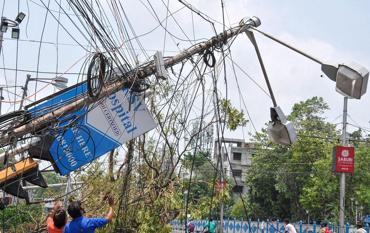 A damaged electric pole hangs close to a road, in the aftermath of super cyclone 'Amphan', in Kolkata. PTI