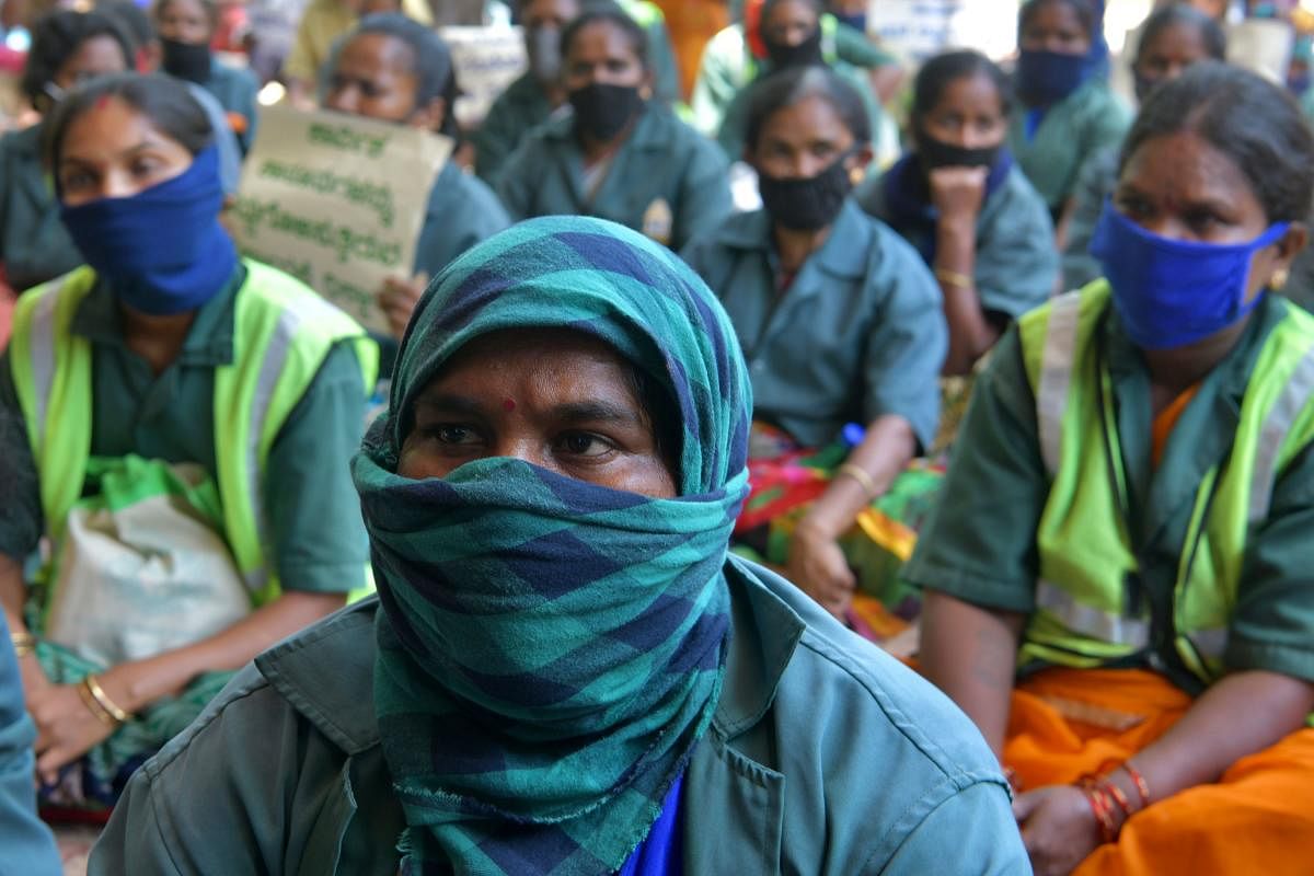 Protestors listen to their leader speak during a protest staged by workers during an All India Protest called by Trade Unions belonging to various public and private sector sector companies against the alleged unfriendly labour policies moved by the Indian government in amidst the coronavirus crisis, in Bangalore on May 22, 2020. Credit: AFP Photo