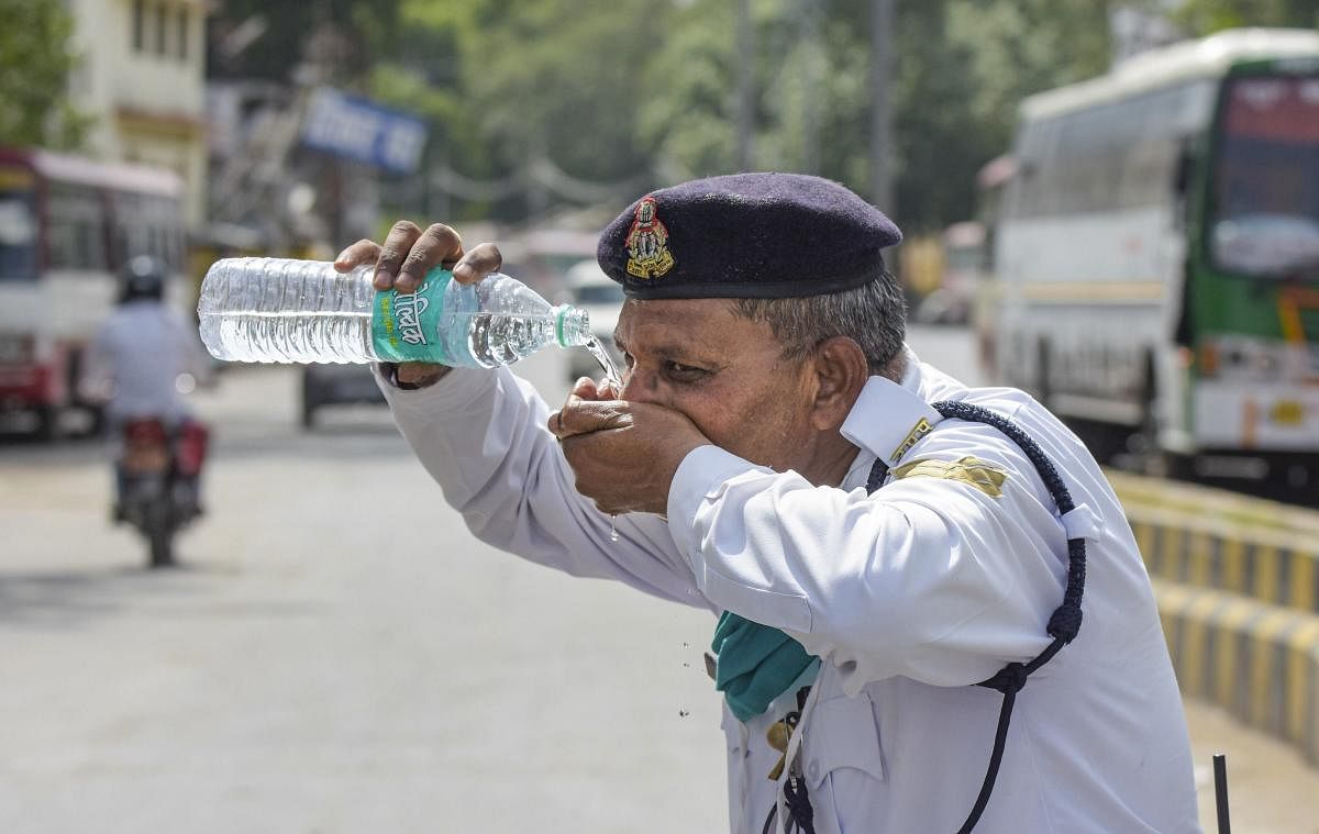 A traffic policeman drinks water during a hot summer day in Uttar Pradesh (PTI  Photo)