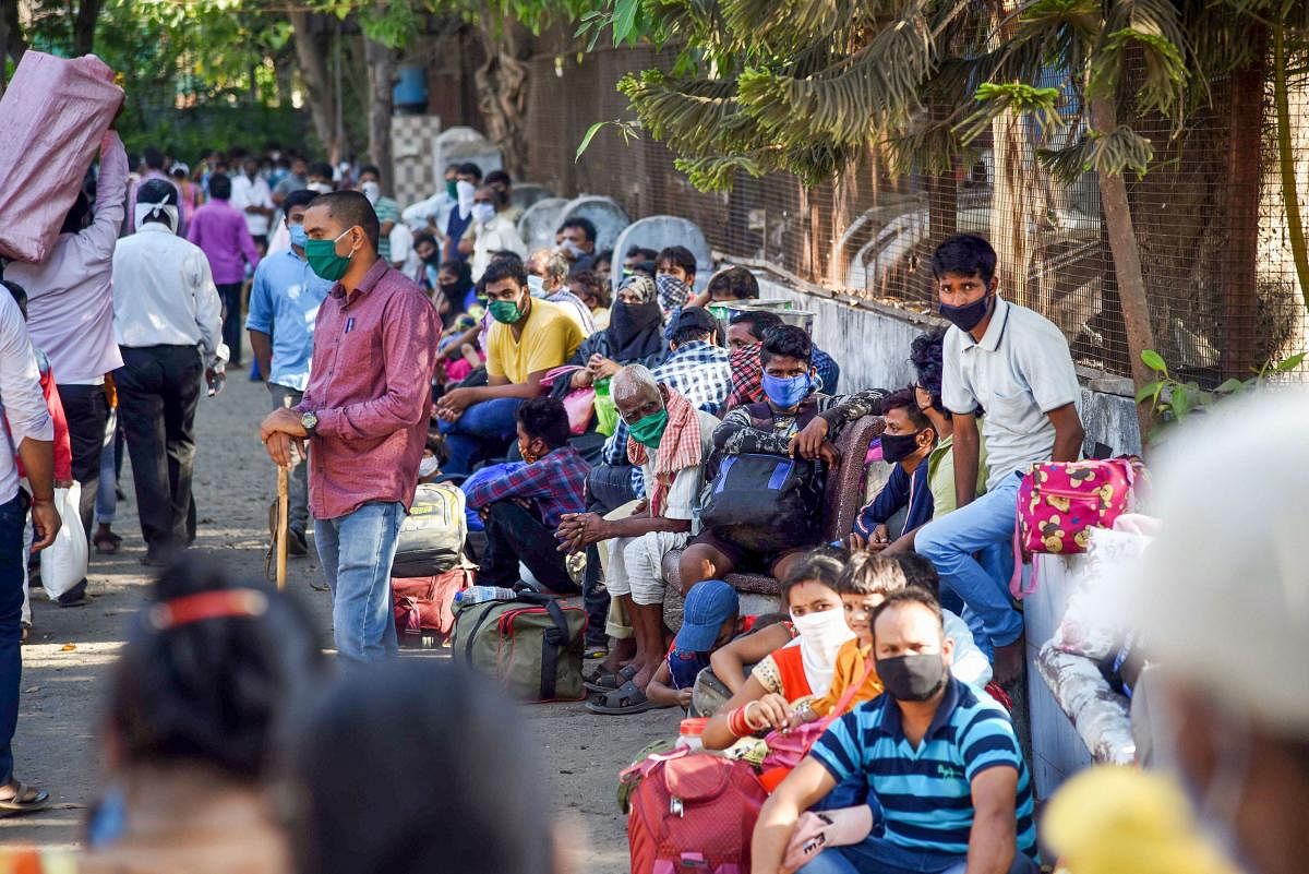 Migrants from Gonda district in Uttar Pradesh wait to board a bus for Thane Railway Station for their onward journey by train to reach their homes, during ongoing COVID-19 lockdown, in Navi Mumbai, Friday, May 22, 2020. (PTI Photo)