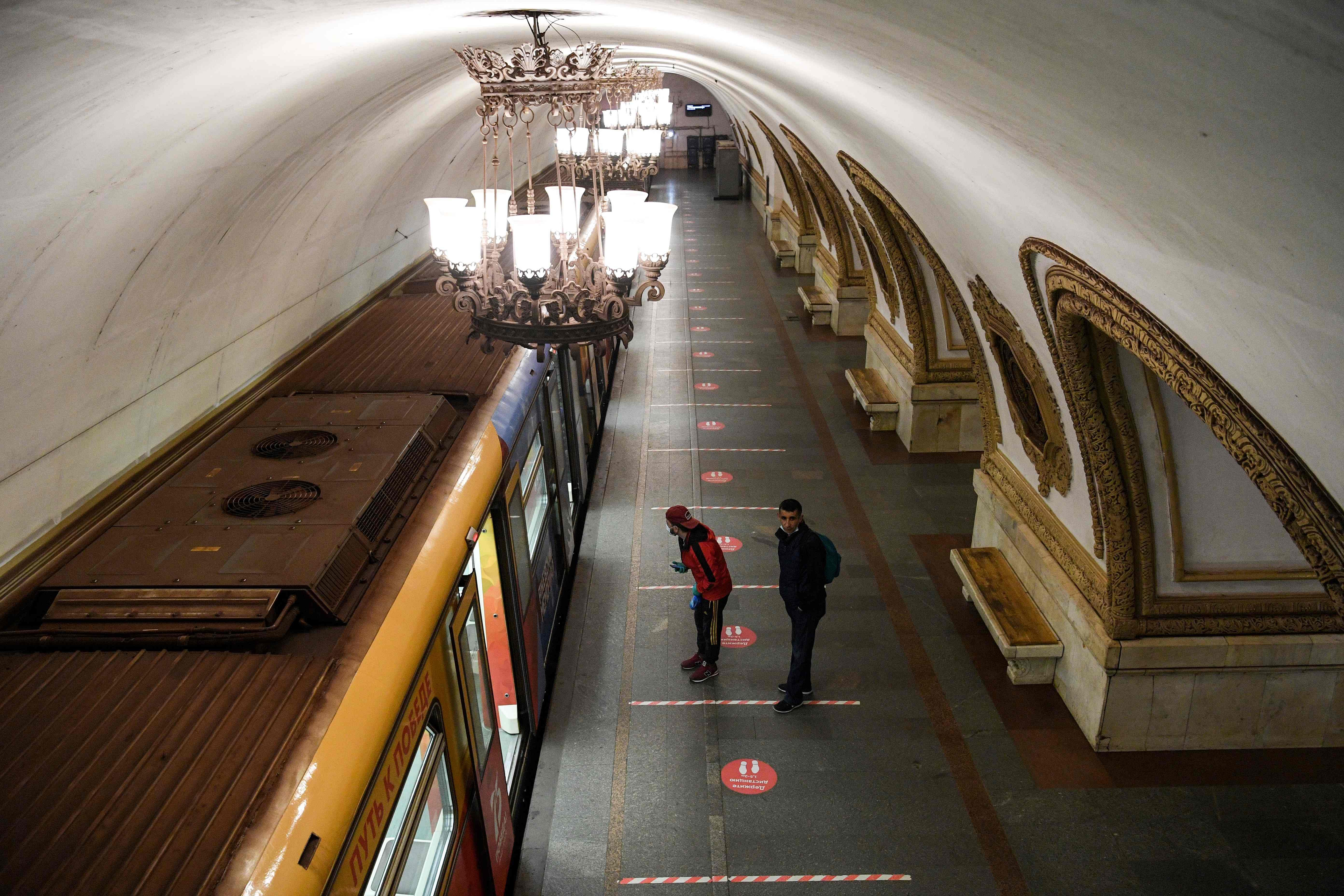 Men wearing a protective masks walk on a platform at the Kievskaya metro station in Moscow. (AFP photo)