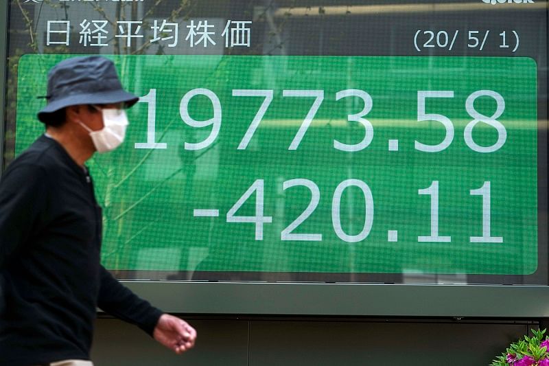 A man walks past an electronic stock board showing Japan's Nikkei 225 index. (AP Photo)