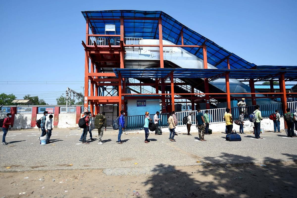 Migrant workers and their family members queue to enter inside a railway station (AFP Photo)