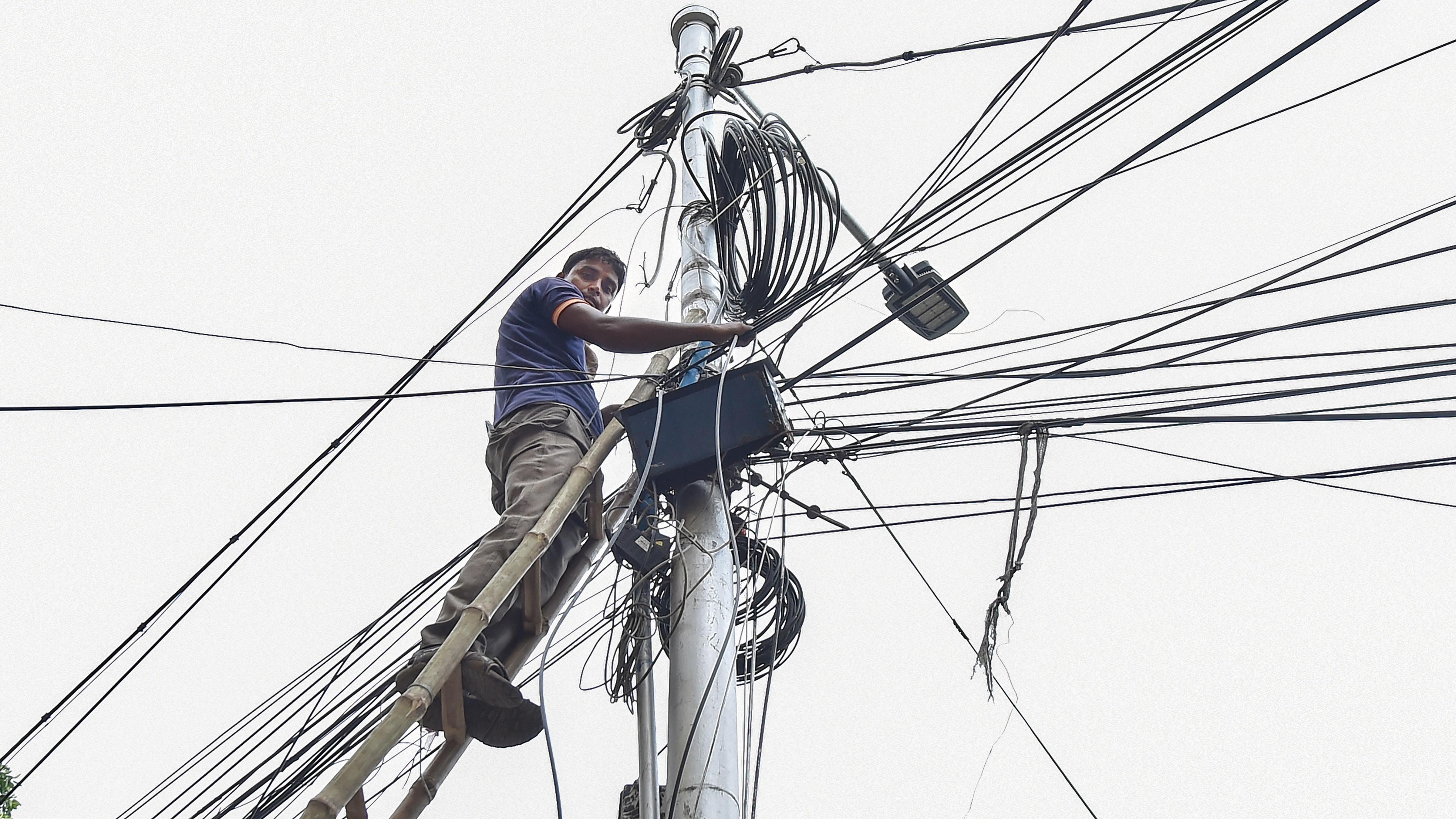 A worker restores an internet service in the aftermath of Cyclone Amphan, in Kolkata, Tuesday, May 26, 2020. (PTI Photo)