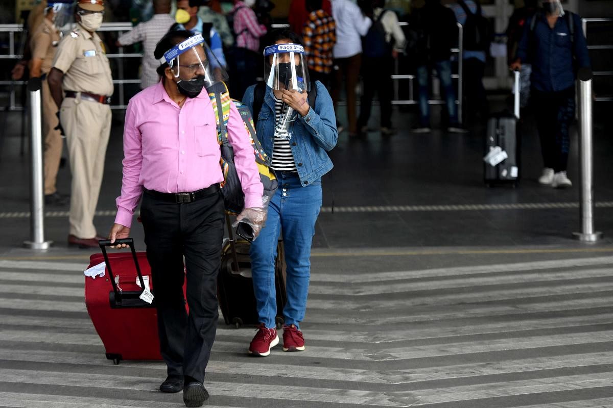 Passengers wearing protective face shields arrive at the Kamaraj domestic airport (AFP Photo)