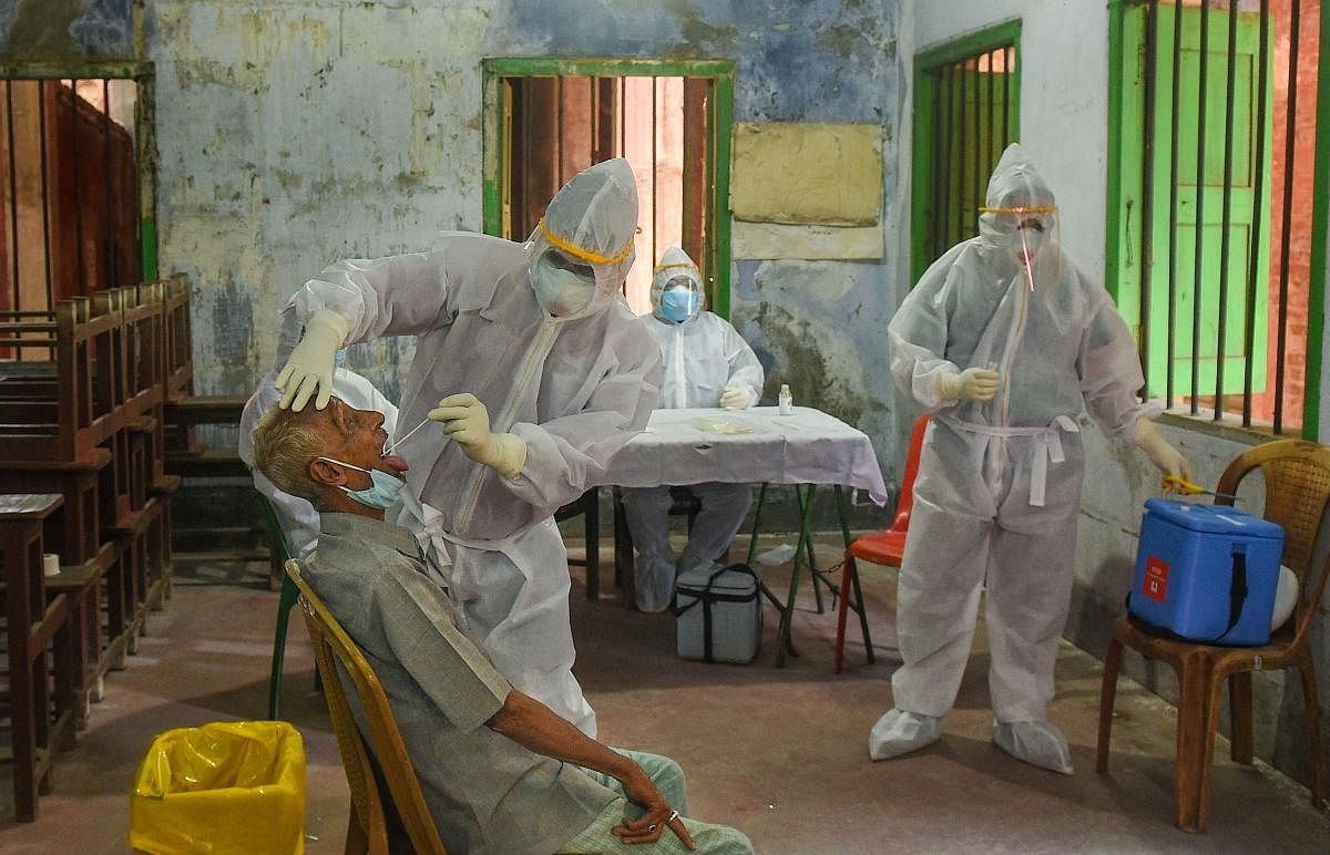 A health worker takes samples for COVID-19 swab tests as others look on, during the ongoing nationwide lockdown to curb the spread of coronavirus, in Kolkata, Monday, May 11, 2020. (PTI Photo)