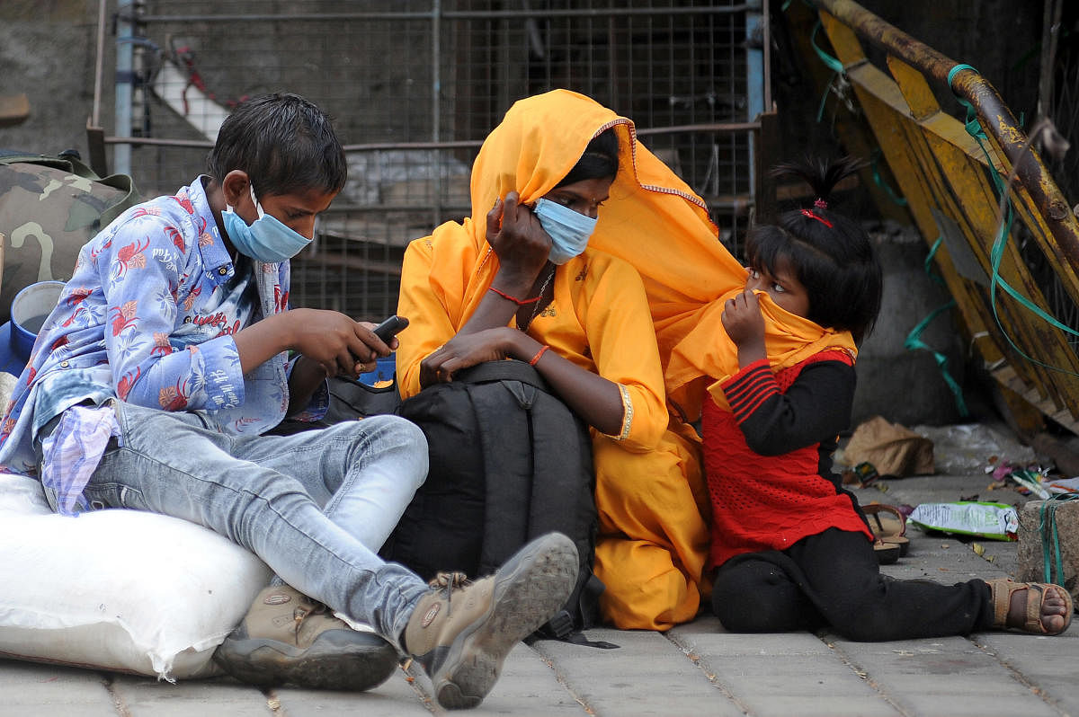 A migrant family waits near Majestic in Bengaluru to return home. DH Photo/Pushkar V