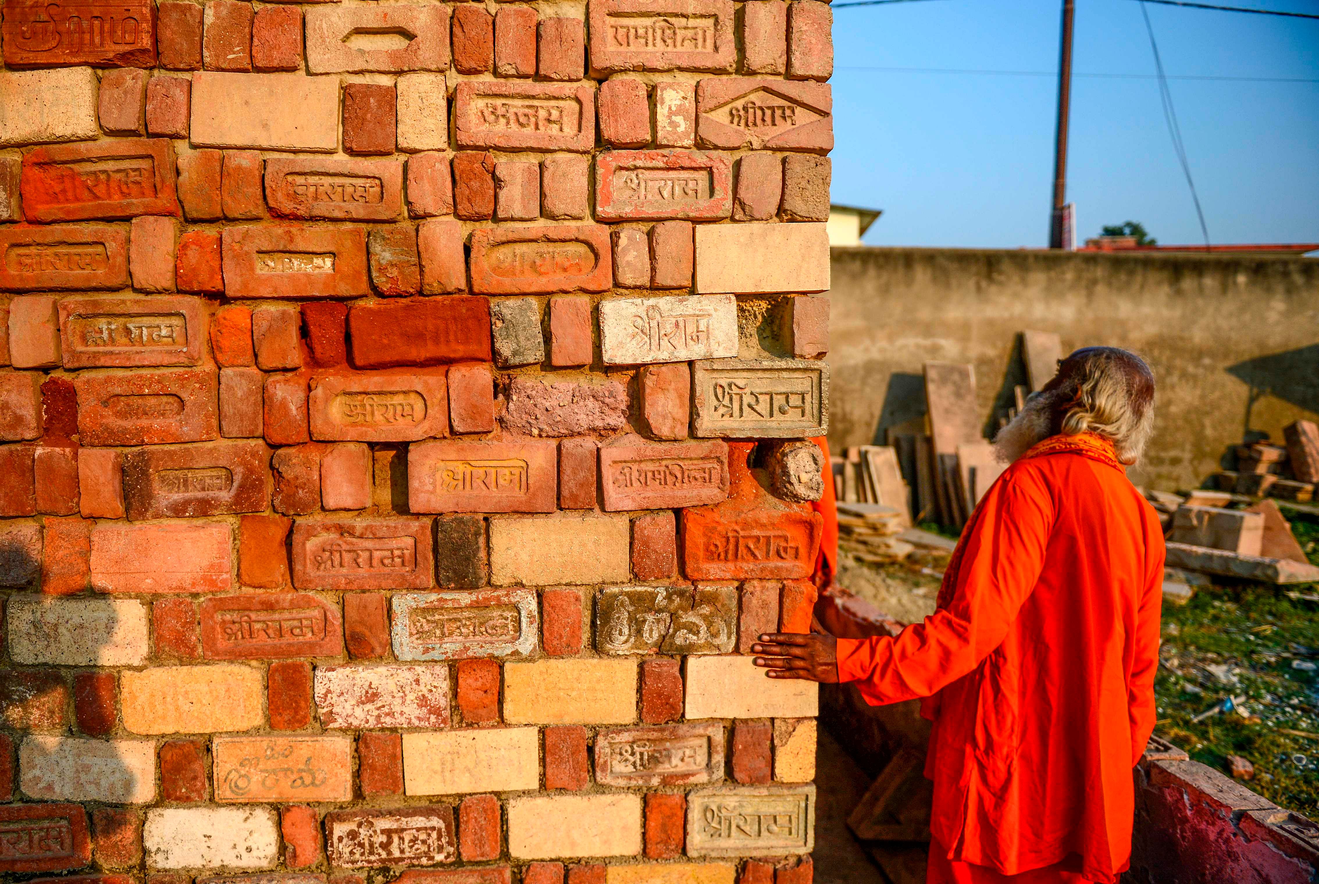 In this picture taken on November 12, 2019, a Sadhu (Hindu holy man) looks at bricks for the proposed Rama temple Ram Janmabhoomi Nyas workshop in Ayodhya, after the Supreme Court verdict on the disputed religious site. (AFP photo)