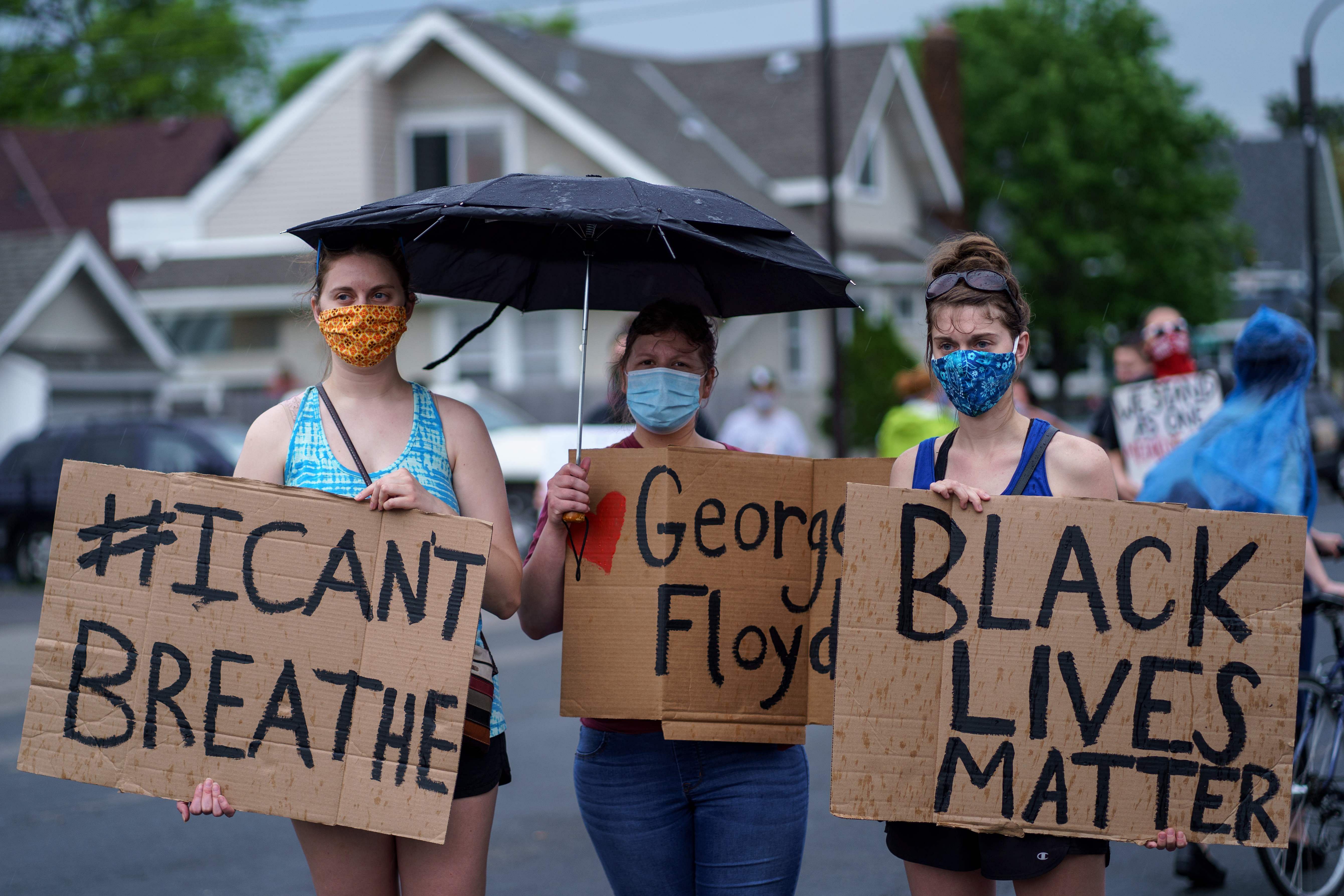 Women hold signs while protesting near the area where a Minneapolis Police Department officer allegedly killed George Floyd. (AFP photo)