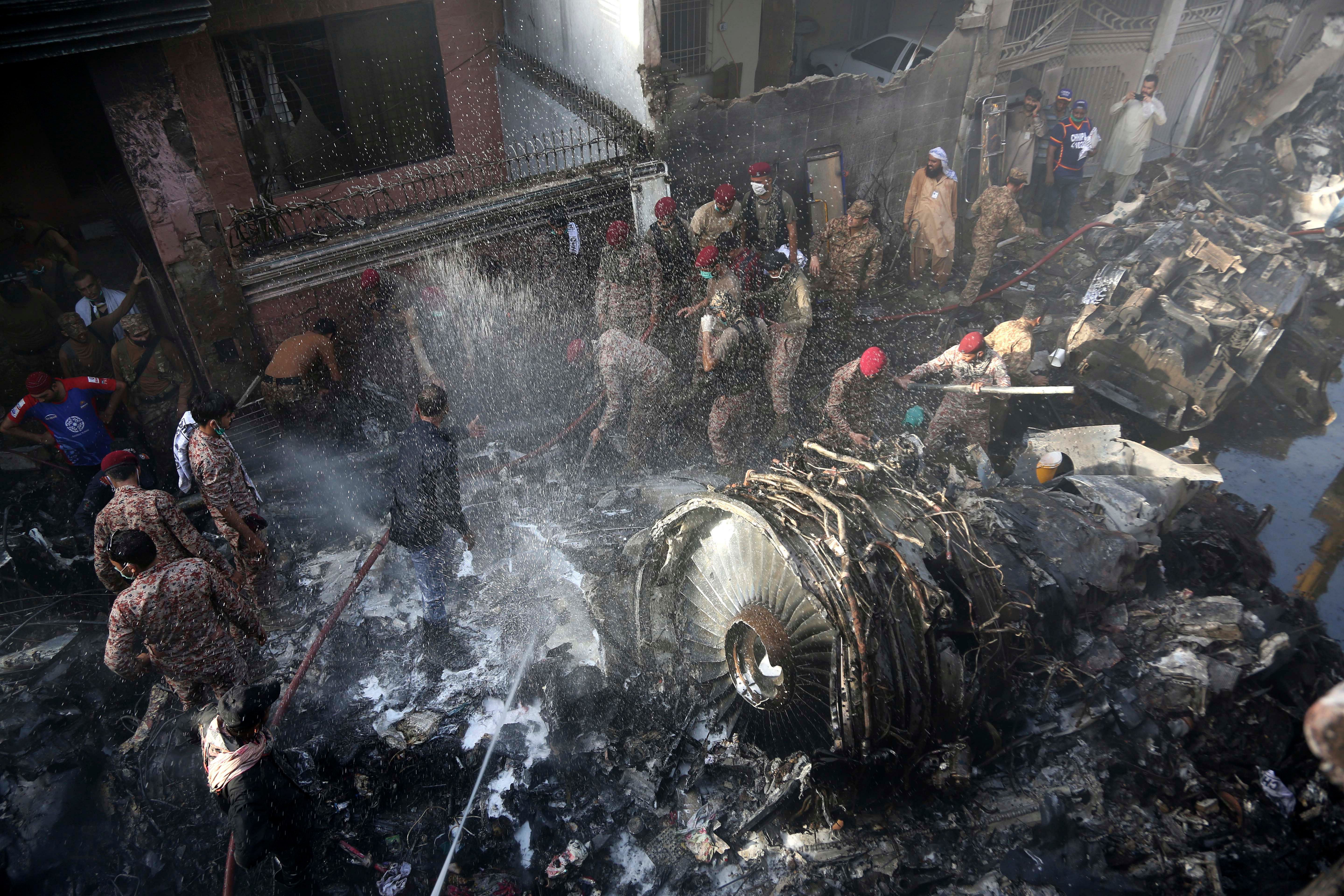 Volunteers look for survivors of a plane that crashed in residential area of Karachi, Pakistan. (AP photo)