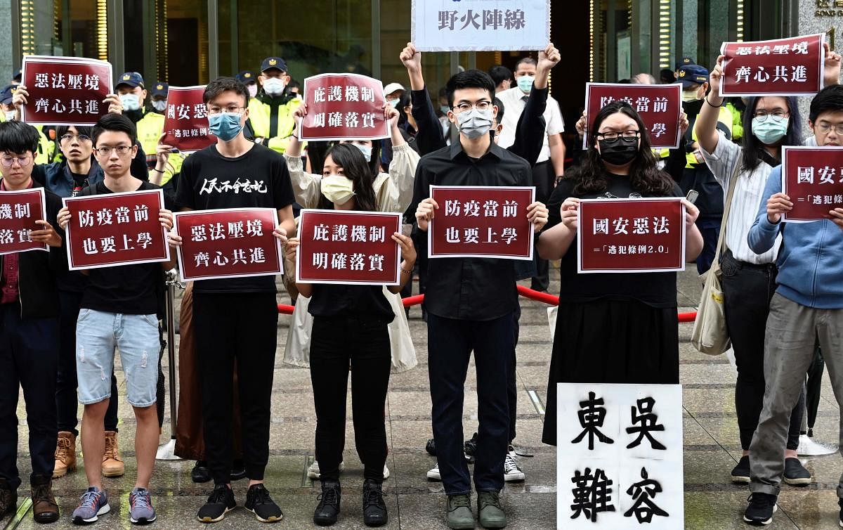 Students from Hong Kong and Taiwan display placards reading “Bad laws of China’s national security" during a protest outside the Hong Kong’s Taipei office (AFP Photo)