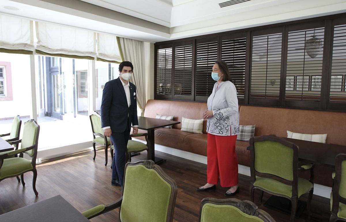 Manager Karin Ansos and trainee Tim Spoehr prepare the restaurant on May 18, 2020 at luxurious five-star Kempinski hotel in Gravenbruch just outside Frankfurt am Main, western Germany, amid the coronavirus pandemic. AFP