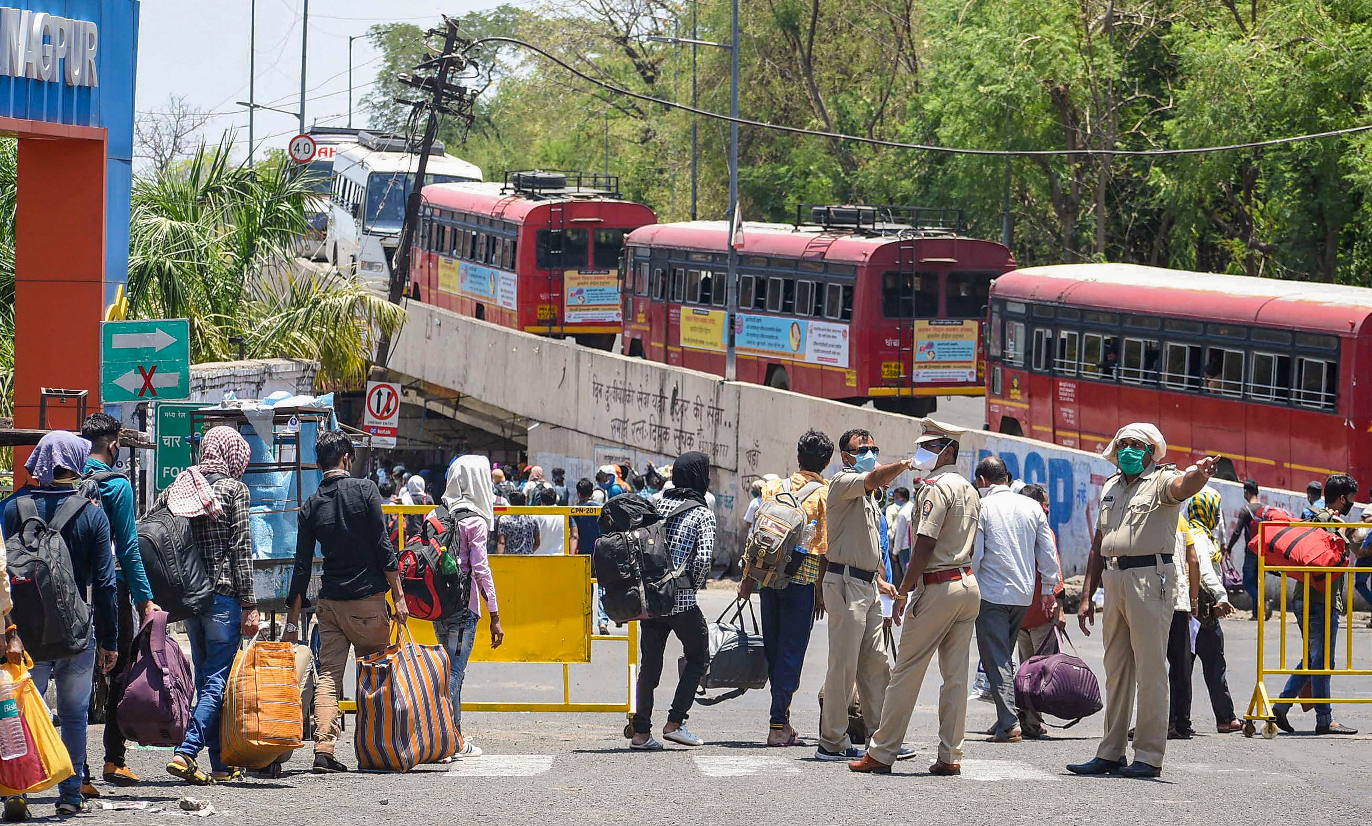 Police check the documents of migrants as they queue up to board buses to leave for their native places, during ongoing COVID-19 lockdown. (PTI Photo)