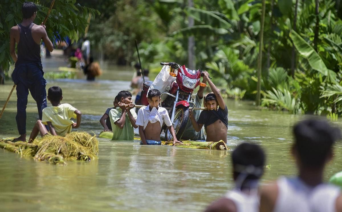Villagers carry a bike on a banana raft in flood-hit locality of Doboka in Hojai district of Assam, Thursday, May 28, 2020. (PTI Photo) 