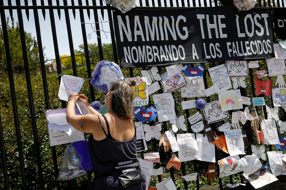 A woman adds a name on a memorial for those who have died from the coronavirus outside The Green-Wood Cemetery, during the outbreak of the coronavirus disease (COVID-19) in Brooklyn, New York. Credit: Reuters Photo