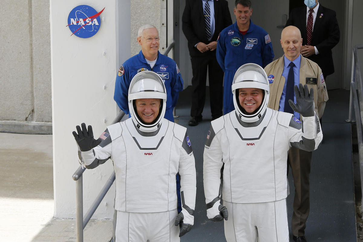 NASA astronauts Douglas Hurley and Robert Behnken wave as they head to Pad39A before the launch of a SpaceX Falcon 9 rocket and Crew Dragon spacecraft at the Kennedy Space Center, in Cape Canaveral, Florida, U.S., May 27, 2020. Credit: Reuters Photo