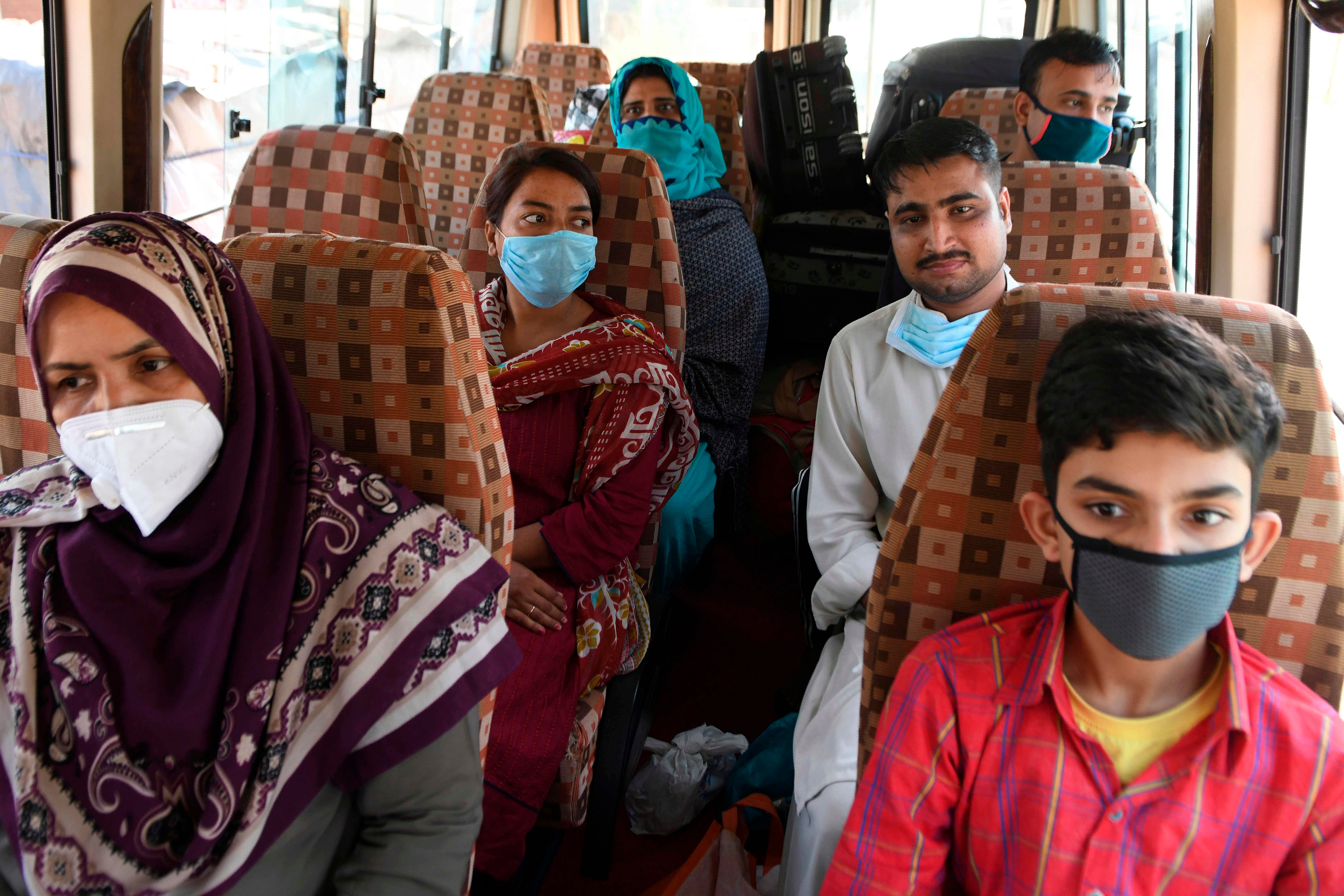 Pakistani nationals, who were stranded in India following the closure of borders due to the COVID-19 coronavirus lockdown, sit inside a mini bus before crossing the India-Pakistan Wagah border post, some 35 kms from Amritsar on May 27, 2020. (Photo by AFP)