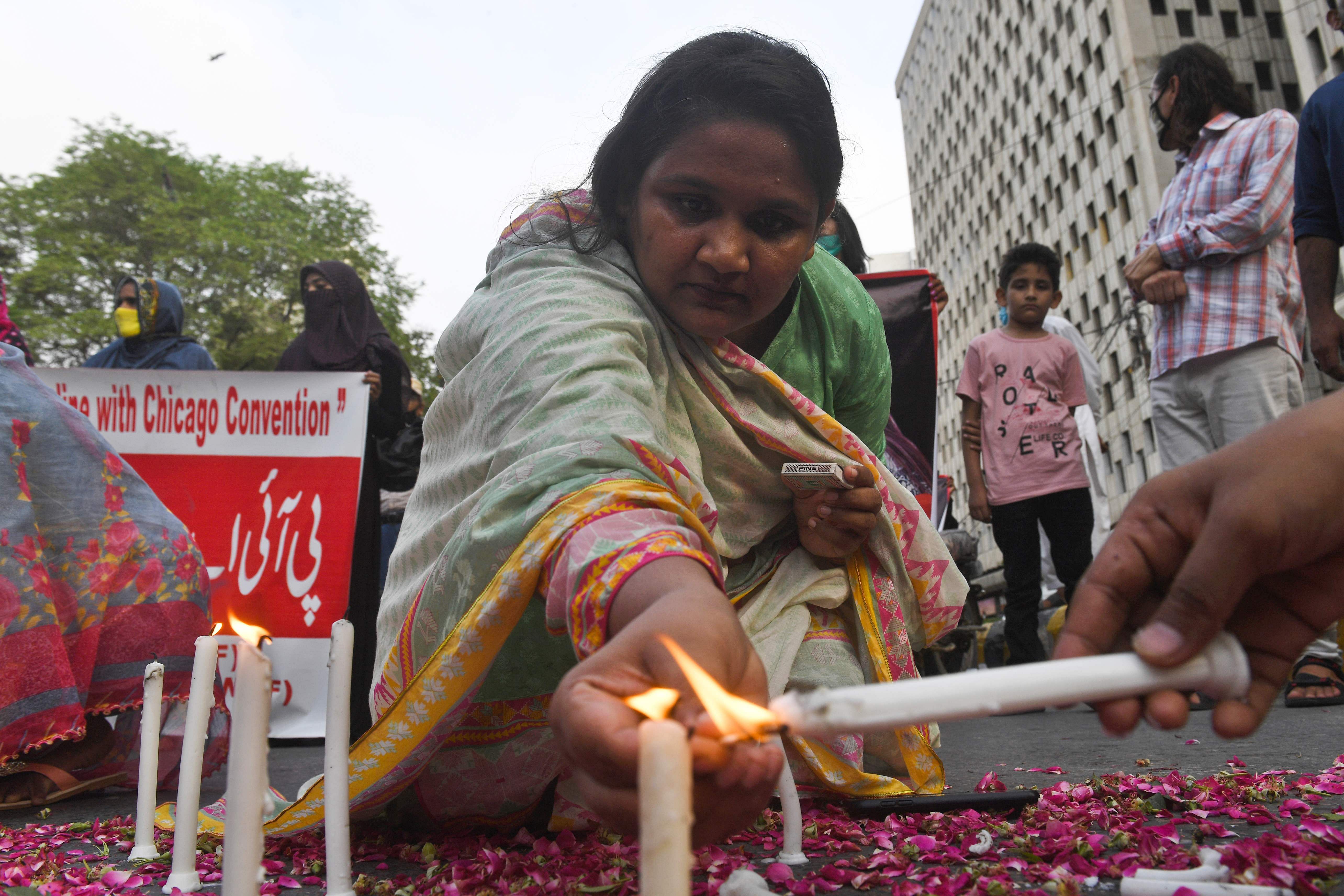Trade union and civil society activists light candles in Karachi on May 28, 2020, during a candlelight vigil for the victims of the Pakistan International Airlines (PIA) plane crash on May 22. (AFP Photo)