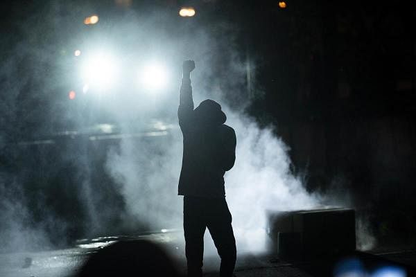  A protester holds up a fist in a cloud of tear gas outside the Third Police Precinct building on May 28, 2020 in Minneapolis, Minnesota. Police and protesters continued to clash for a third night after George Floyd was killed in police custody on Monday. (Stephen Maturen/Getty Images/AFP)