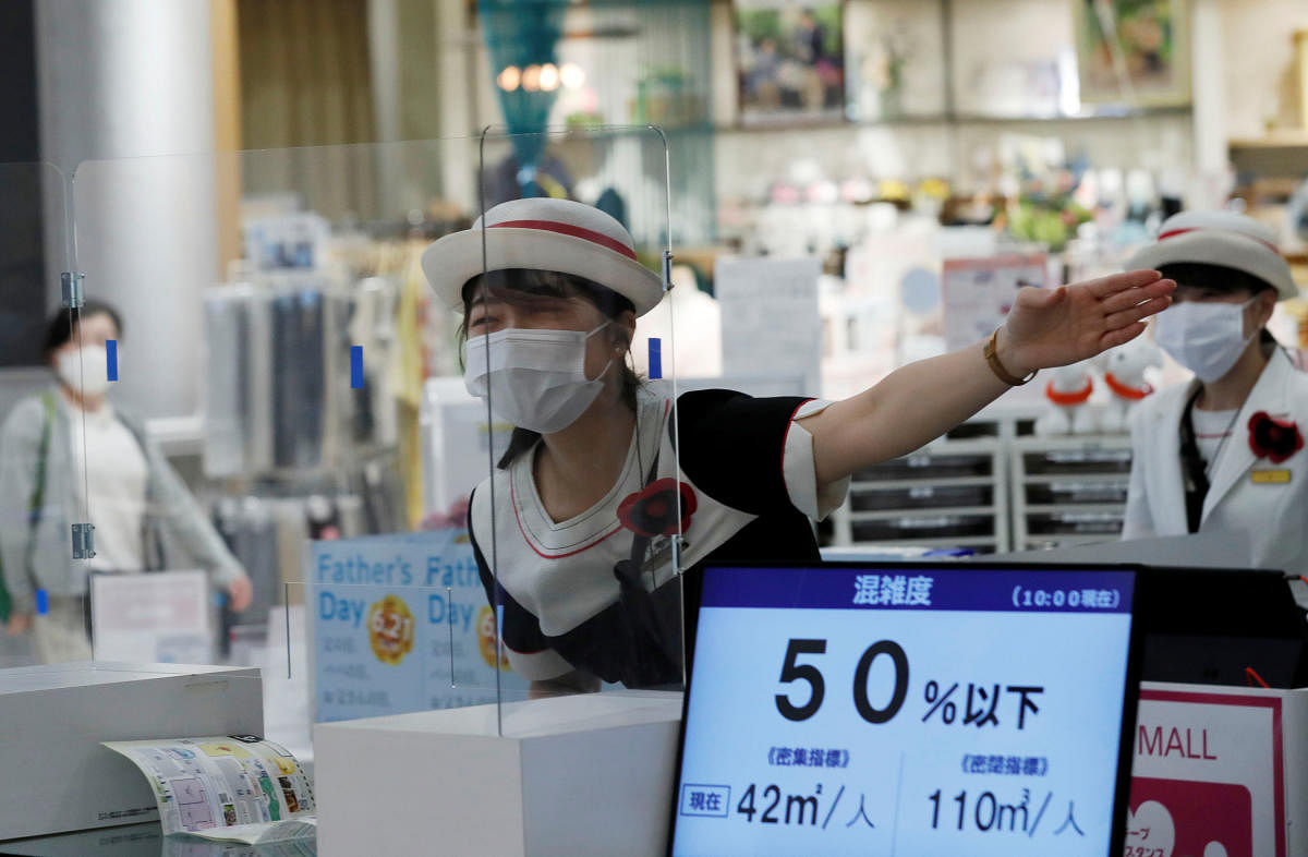 A staff at an information desk talks to a customer through a transparent plastic panel at Japan's supermarket group Aeon's shopping mall as the mall reopens amid the coronavirus disease (COVID-19) outbreak in Chiba. Reuters