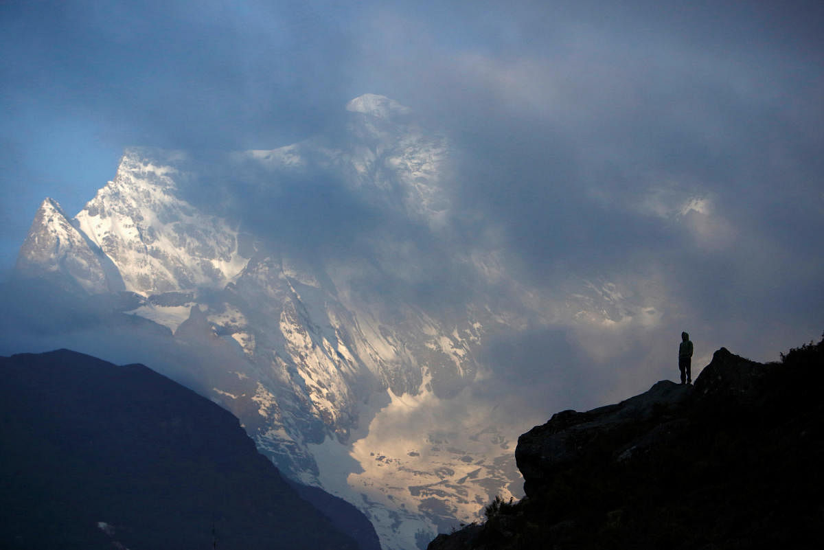 FILE PHOTO: File picture of a Nepali Sherpa silhouetted as he stands in front of Mount Kongde. Reuters