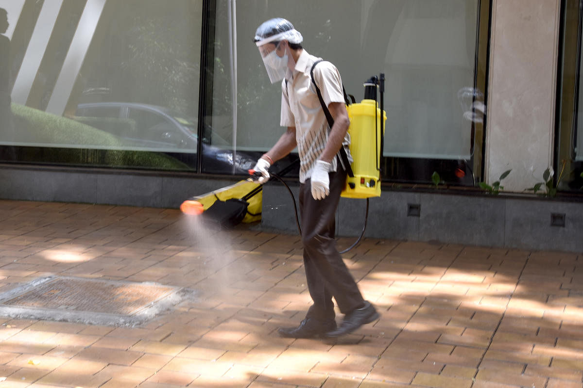 Workers cleaning and spray chemical to fresh the premises of private hotel due to prevention of Coronavirus (DH Photo)