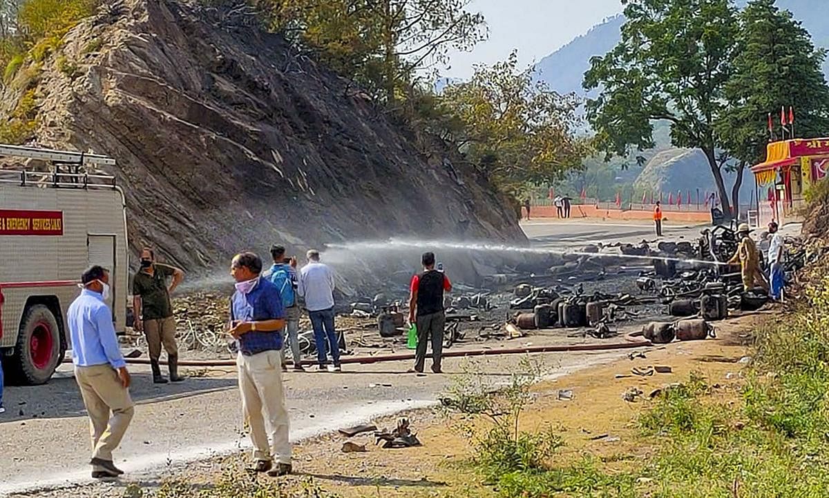Fire personnel douse the fire which broke out in a truck carrying LPG cylinders at Tikri in Manthal area of Udhampur district. PTI