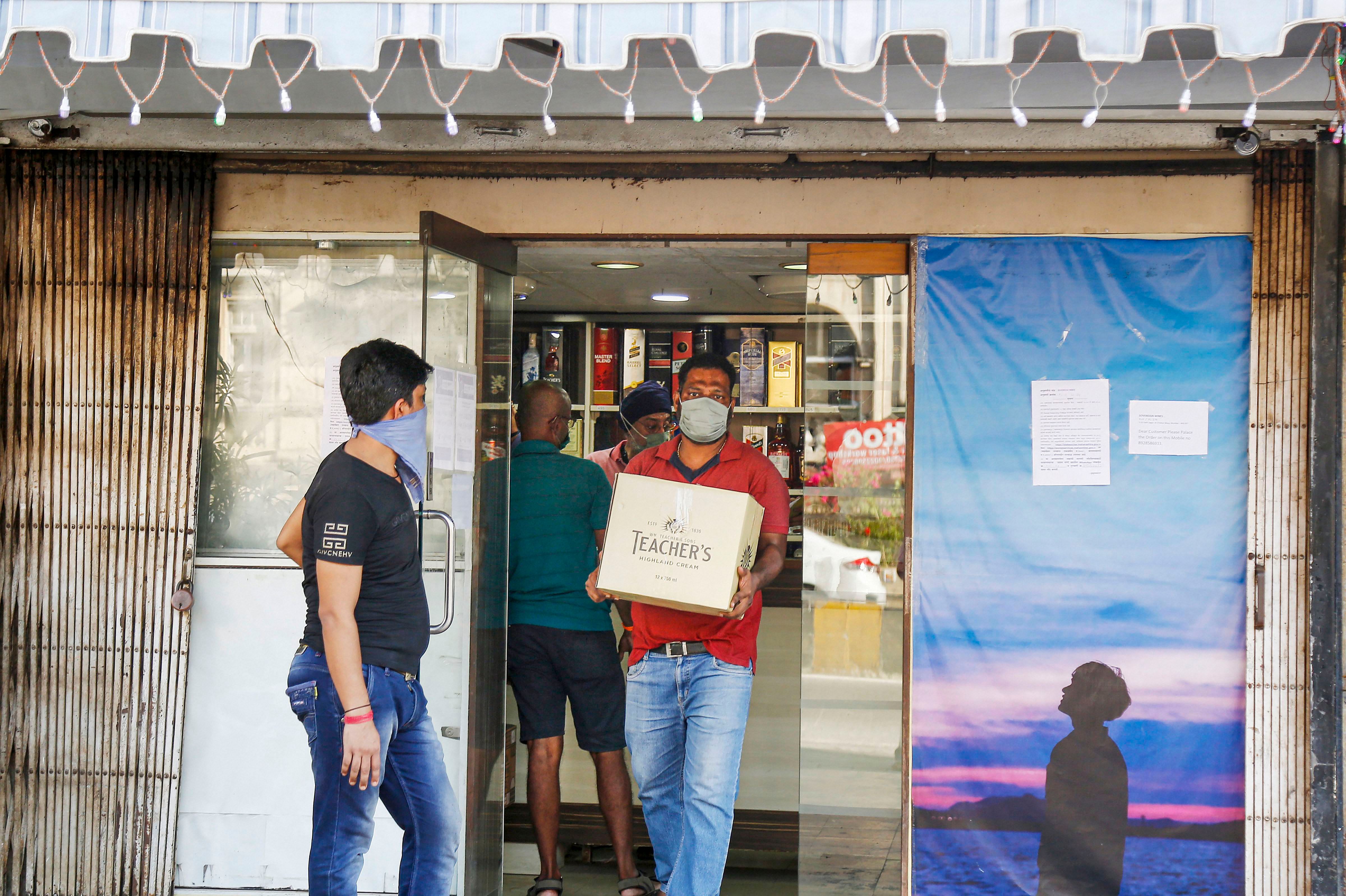A customer leaves after buying liquor from a local wine shop, during the ongoing COVID-19 lockdown, in Mumbai. (PTI Photo)