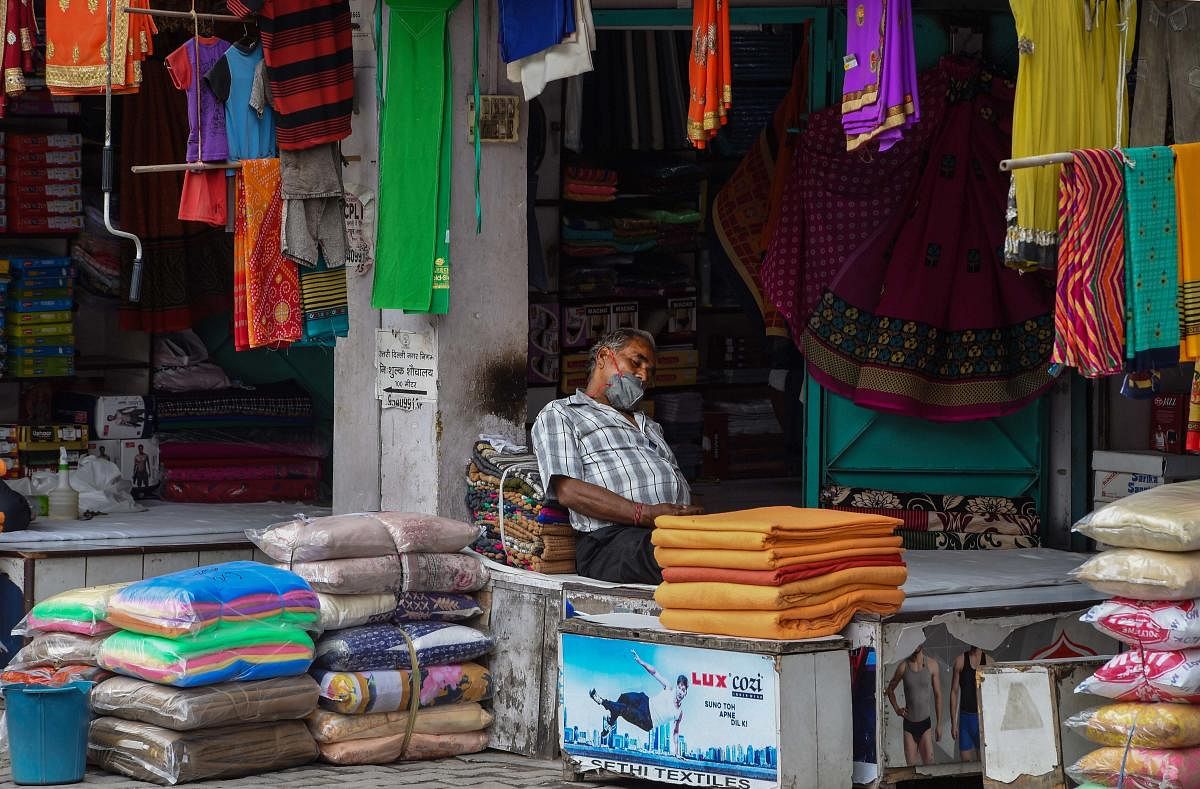 A shopkeeper takes a nap inside his shop during the ongoing COVID-19 nationwide lockdown, in New Delhi (PTI Photo)