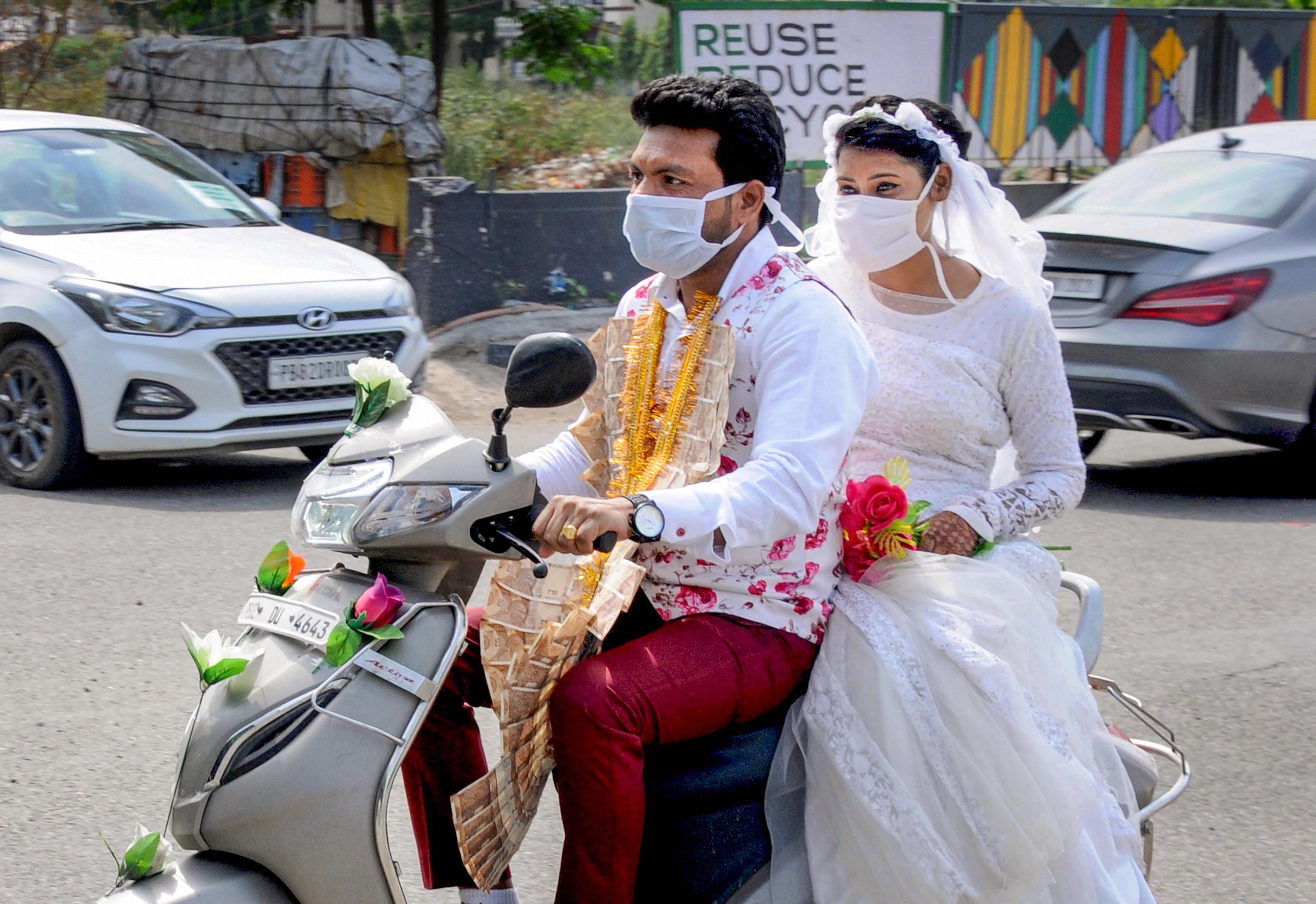 A newly-wed Christian couple ride on a scooter after their marriage ceremony during the ongoing nationwide COVID-19 lockdown, in Amritsar. (PTI photo)