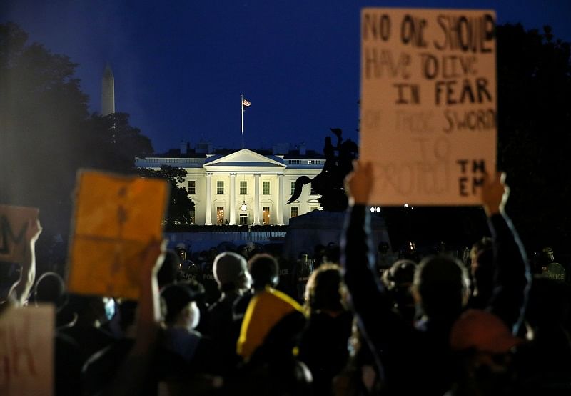 signs during a protest amid nationwide unrest following the death in Minneapolis police custody of George Floyd, near the White House in Washington. (AFP Photo)