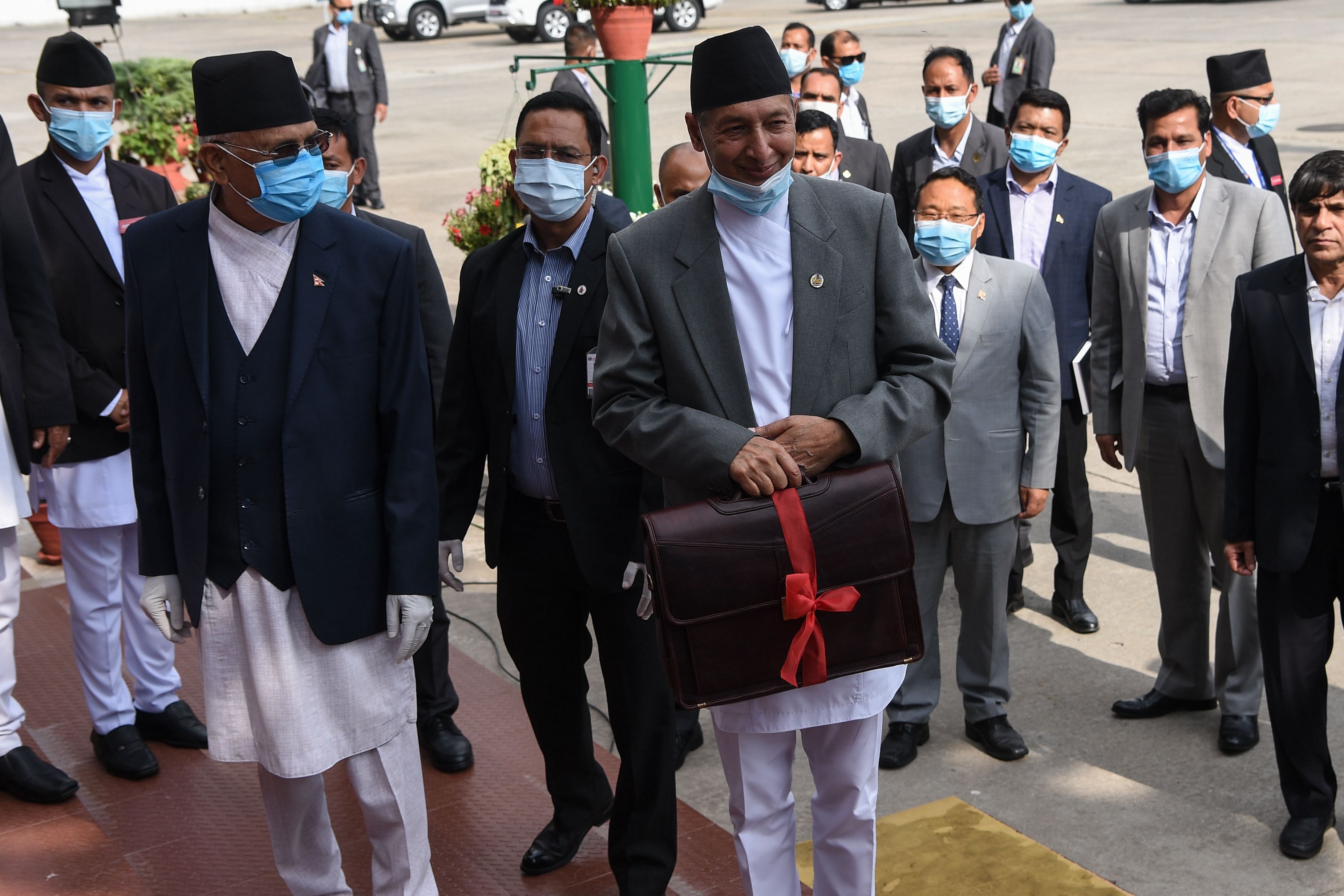 epal's Finance Minister Yubaraj Khatiwada (center R) and Prime minster KP Sharama Oli (L) arrive at the parliament to announce the government's budget for the 2020/2021 fiscal year, in Kathmandu. (AFP Photo)