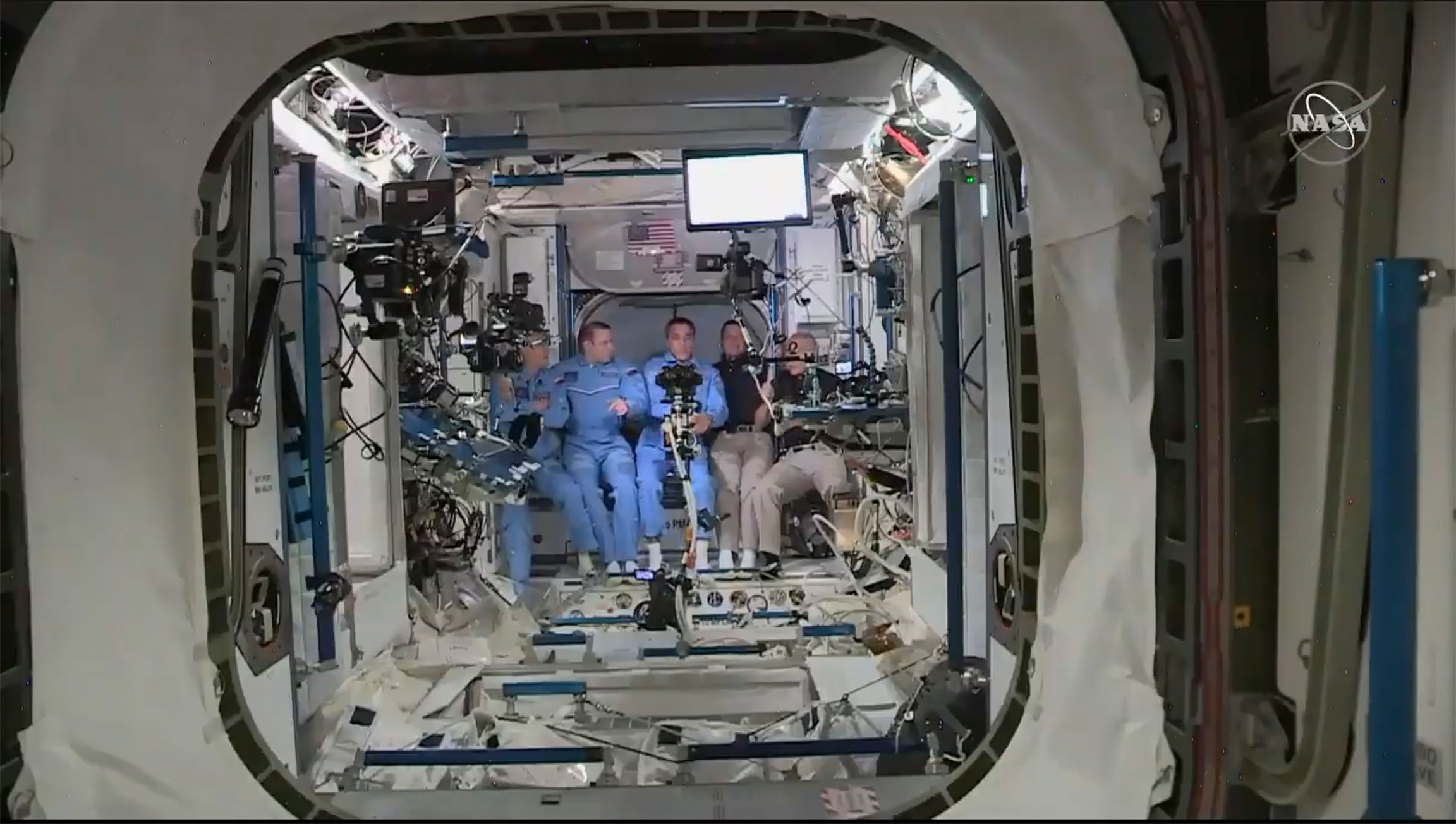 This NASA video frame grab image shows NASA SpaceX’s Crew Dragon astronauts Douglas Hurley(R) and Robert Behnken(2ndR) arriving after the hatch opened to the International Space Station, posing with other astronauts. (AFP image)