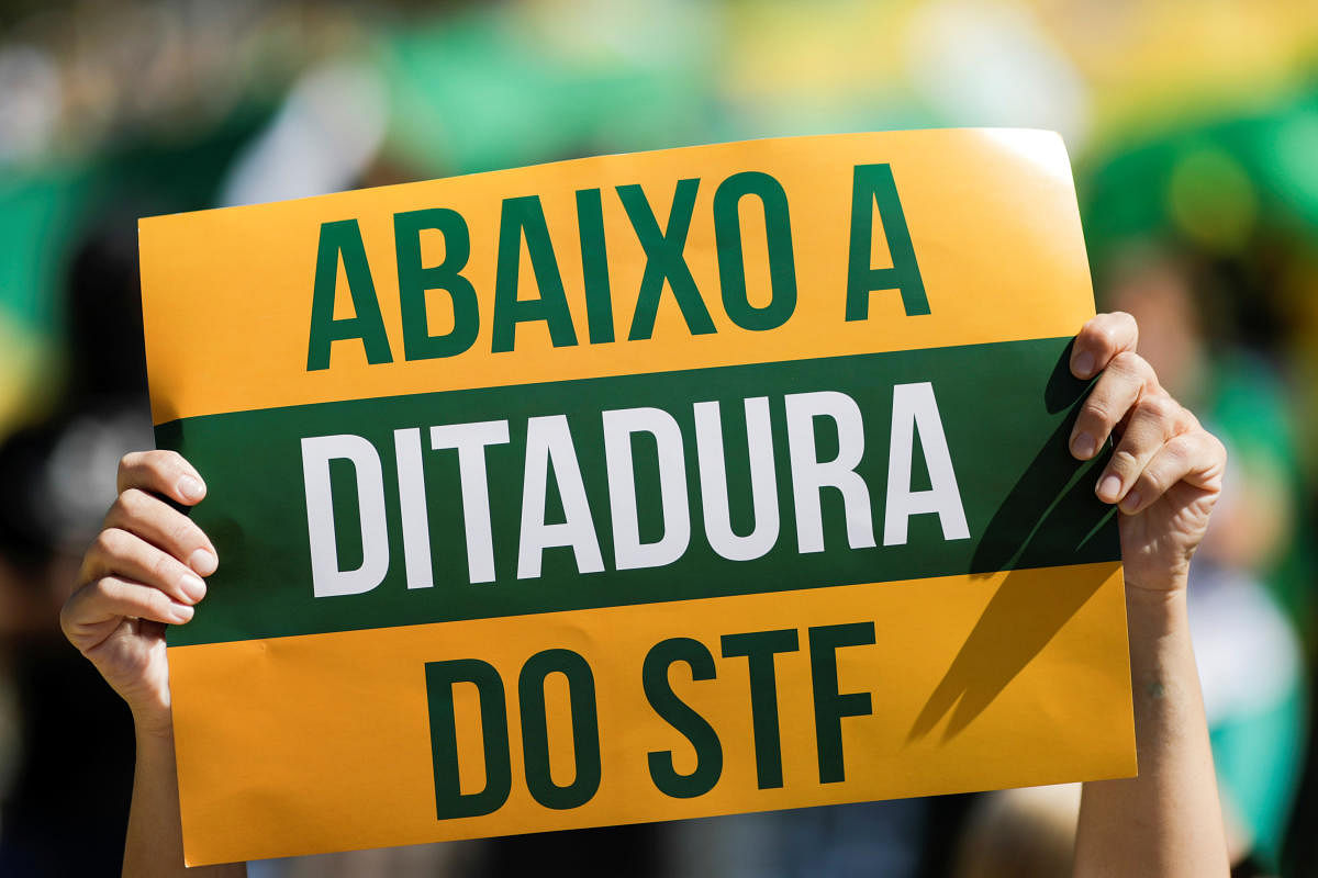 A supporter of Brazilian President Jair Bolsonaro displays a placard  (Reuters Photo)