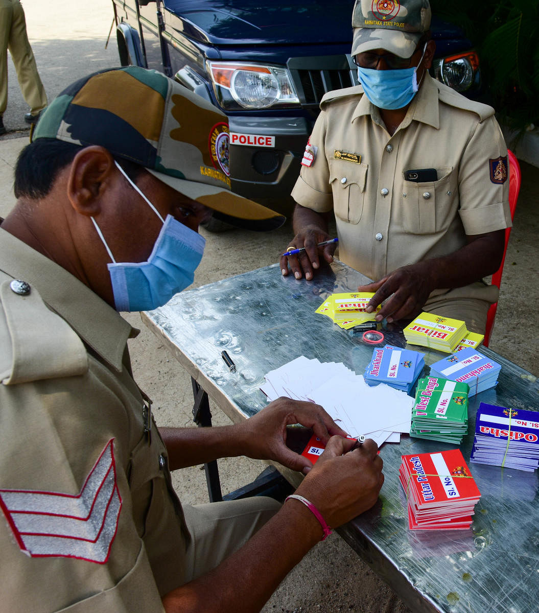 Police personals busy with preparing Passes to issue Migrant labourers, who leave to their native States by special trains, following amid Covid-19 lockdown, at BIEC Ground, in Bengaluru on Friday. Photo/ B H Shivakumar