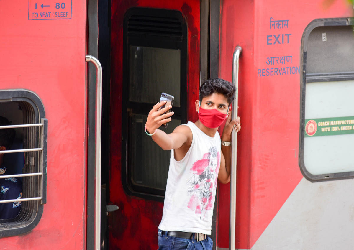 A migrant worker takes a selfie before a Shramik special train leaves for Hatia in Uttar Pradesh from Bengaluru on Sunday. DH Photo/B H Shivakumar