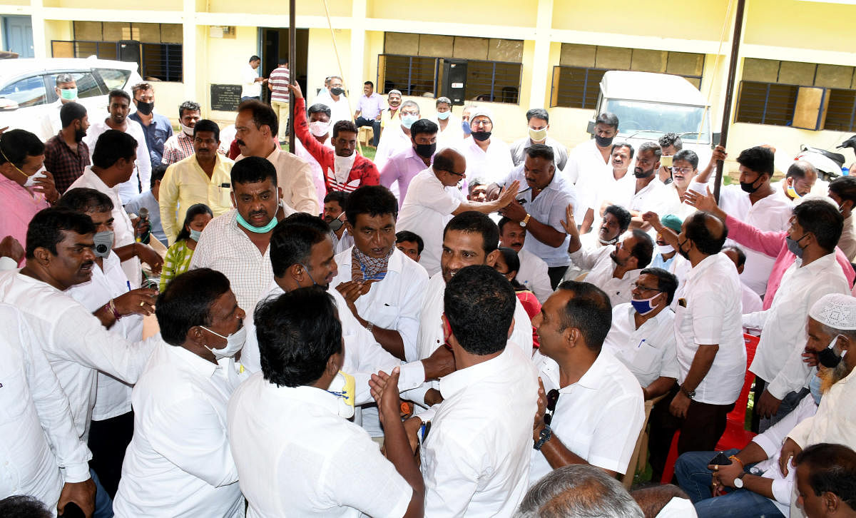Congress leaders try to pacify two groups during a meeting at the Congress office in Hassan on Monday. DH PHOTO