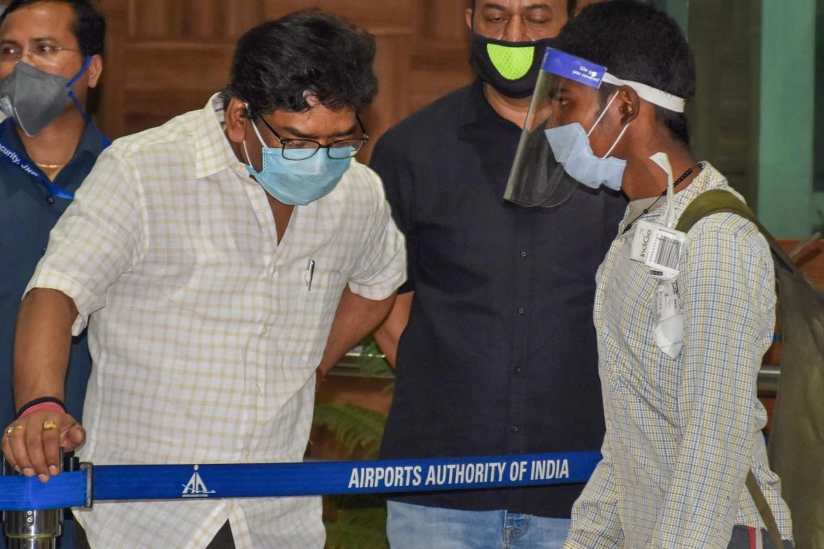 Jharkhand Chief Minister Hemant Soren (L) interacts with a migrant worker as he arrives at Birsa Munda International Airport, during the nationwide COVID-19 lockdown, in Ranchi, Friday, May 29, 2020. Credit: PTI Photo