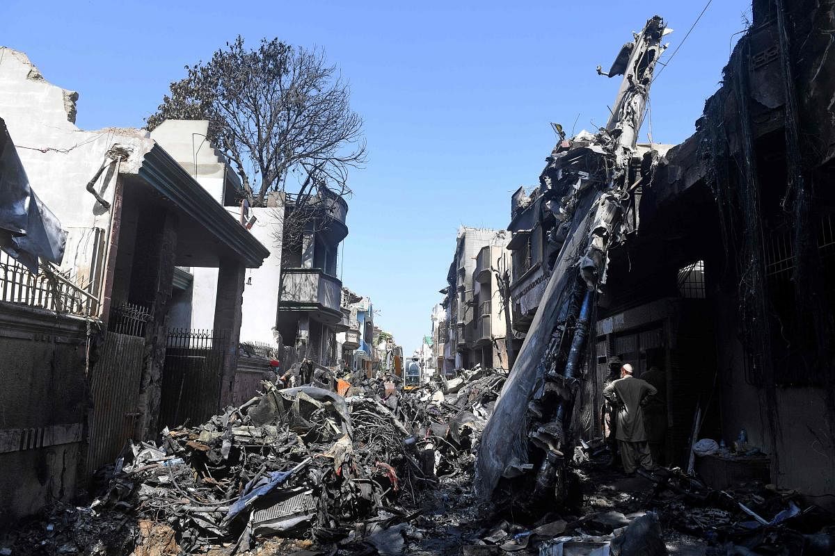  Security personnel stand beside the wreckage of a plane at the site after a Pakistan International Airlines aircraft crashed in a residential area days before, in Karachi on May 24, 2020. Credit: AFP Photo