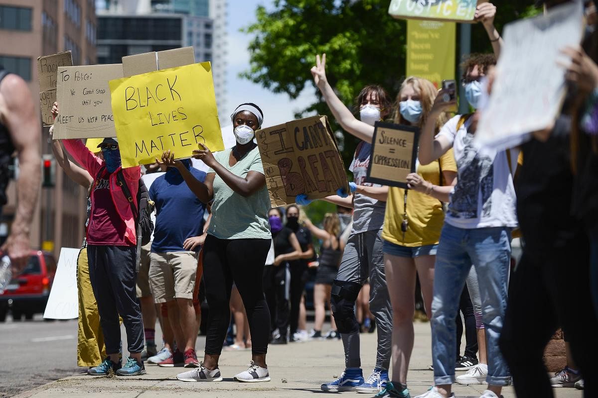 People hold signs near the state Capitol during the fifth consecutive day of demonstrations in the aftermath of the death of African American George Floyd in Denver, Colorado. (AFP Photo)