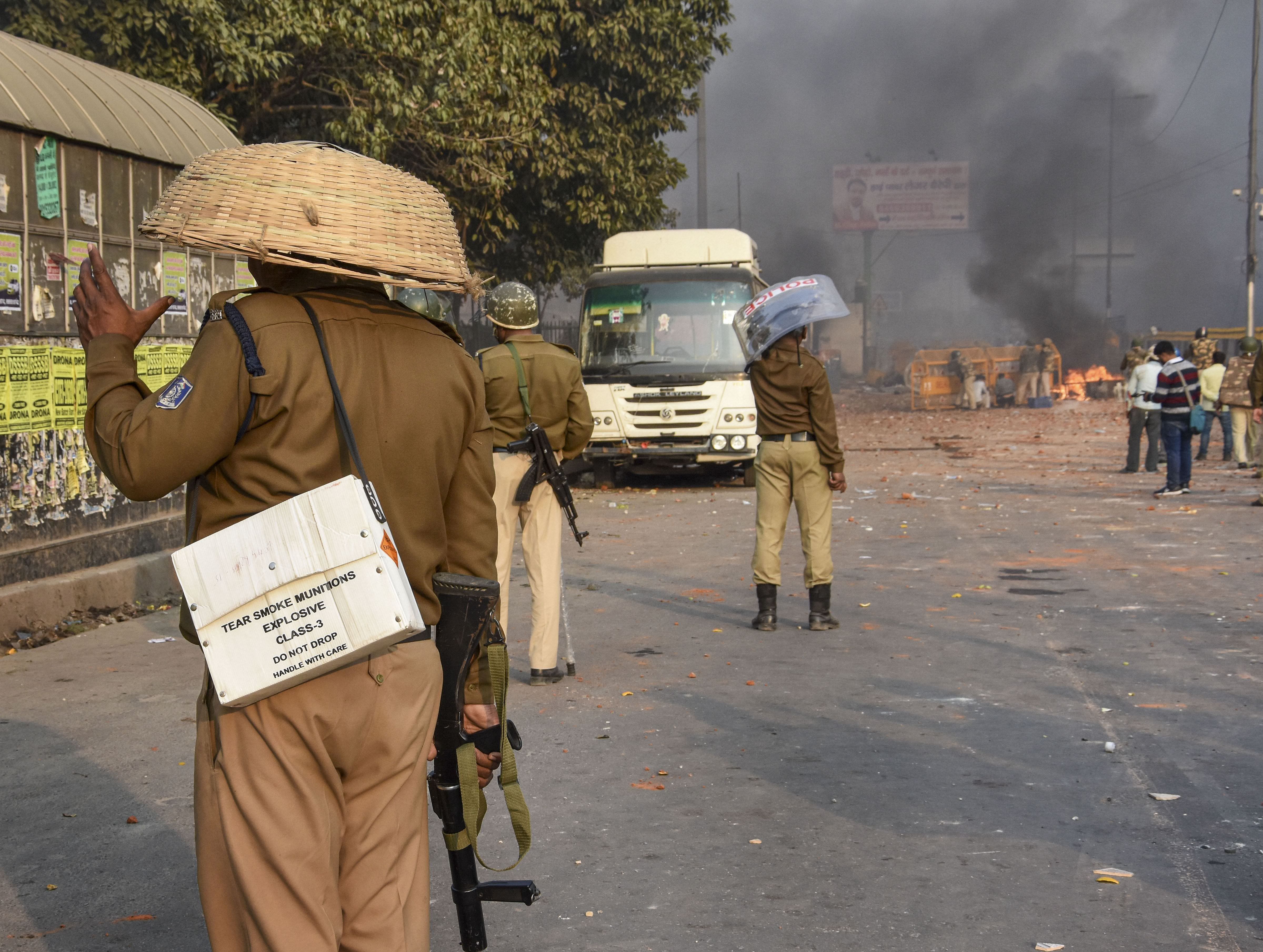  A police personnel uses a bamboo basket as protection against brick-bats during clashes between a group of anti-CAA protestors and supporters of the new citizenship act, at Chand Bagh in Bhajanpura, in north-east Delhi, Monday, Feb. 24, 2020. (PTI Photo)