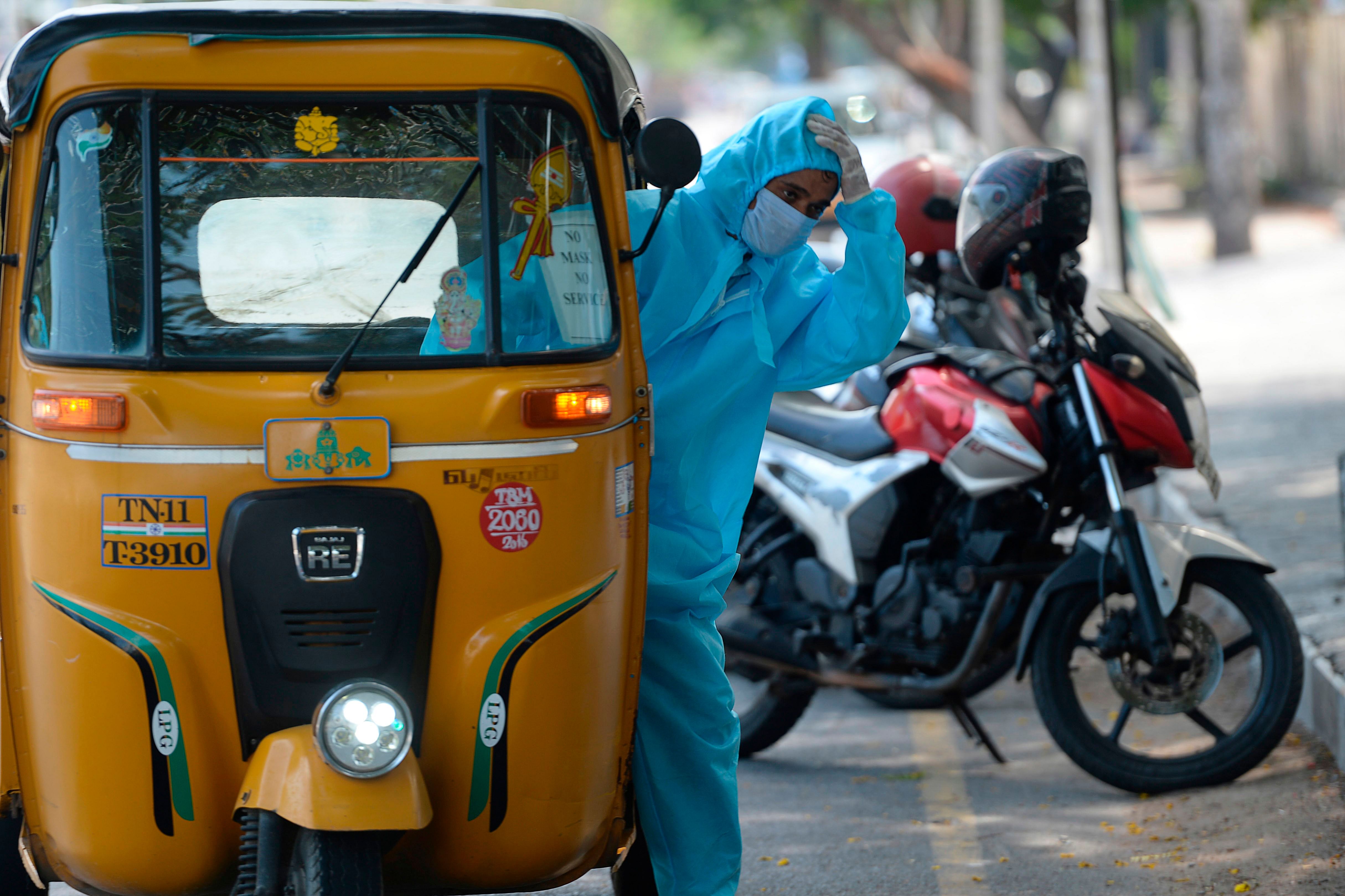 An auto rickshaw driver wearing personal protective equipments (PPE) gestures after the government eased a nationwide lockdown imposed as a preventive measure against the COVID-19 coronavirus, in Chennai. (AFP Photo)