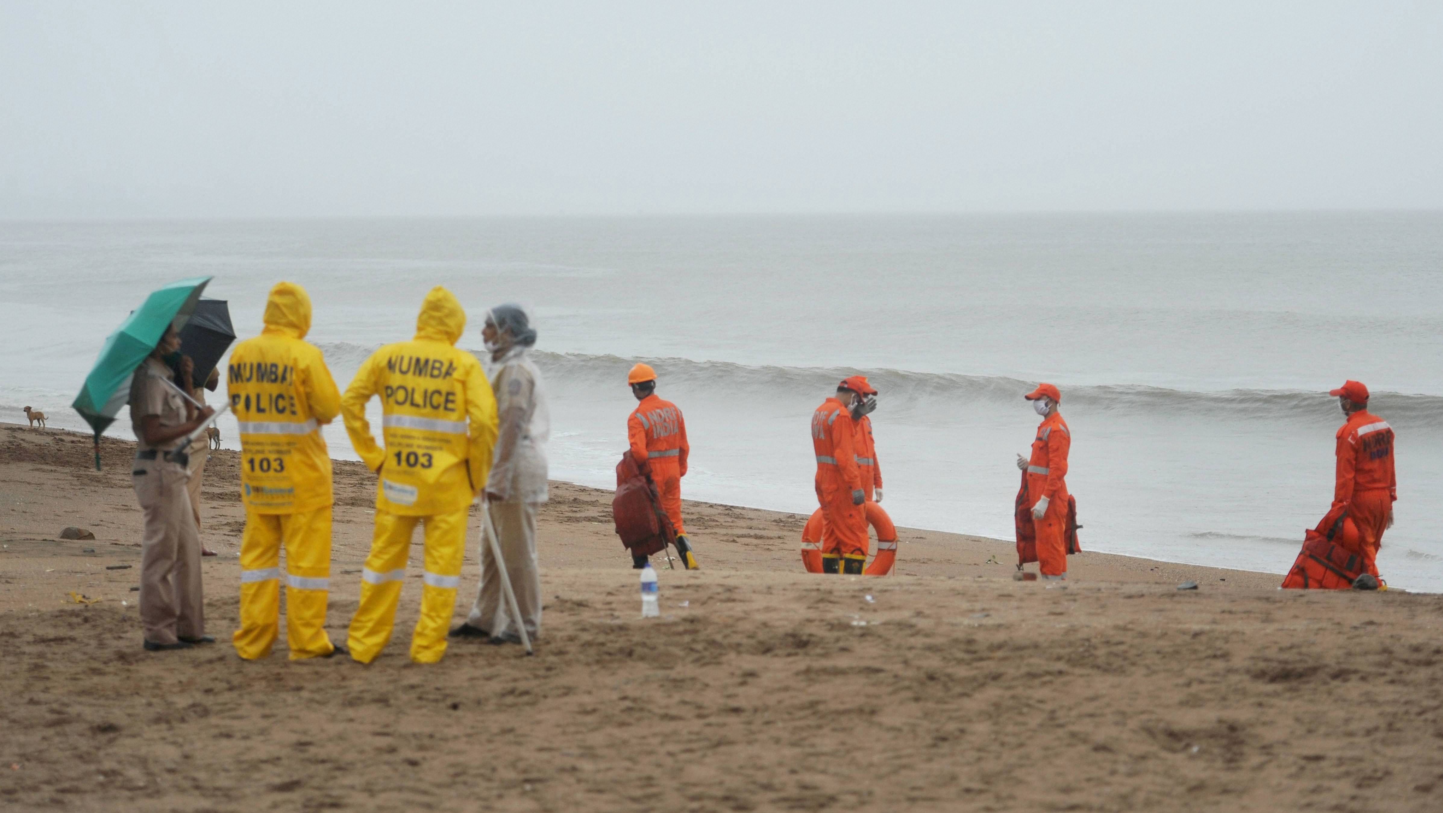 National Disaster Response Force (NDRF) teams evacuate people living along Versova beach. (PTI Photo)