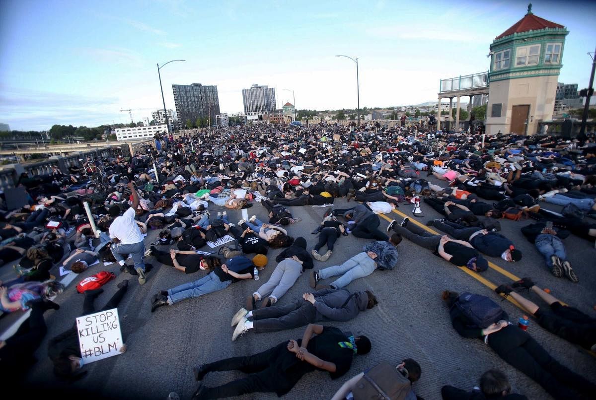 Marchers lay down on the Burnside Bridge for nine minutes on Tuesday evening, June 2, 2020, symbolizing the amount of time a Minneapolis police officer knelt on George Floyd's neck. Floyd died after being restrained by Minneapolis police officers on May 25.AP/PTI